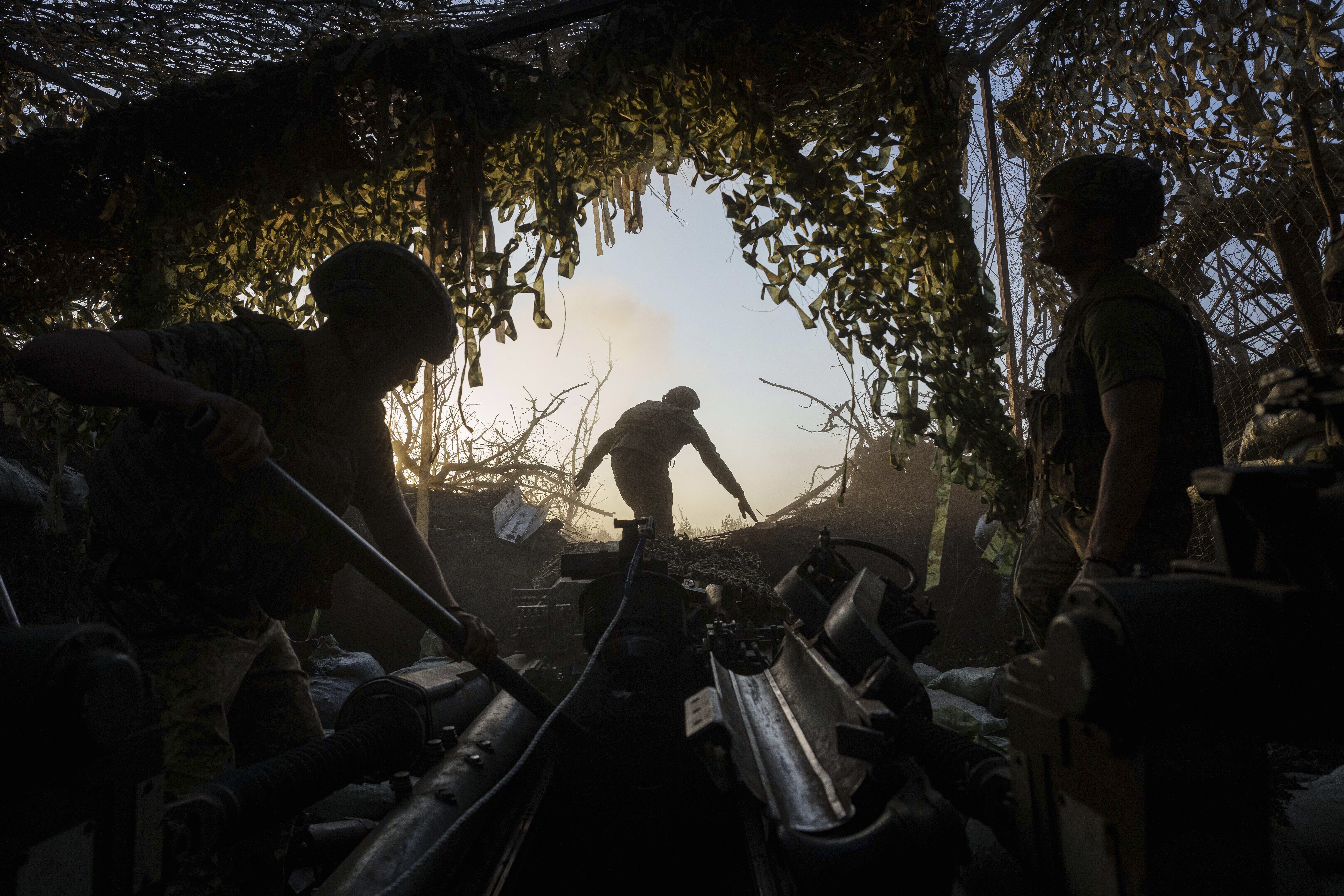 Ukrainian soldiers preparing to fire a howitzer gun