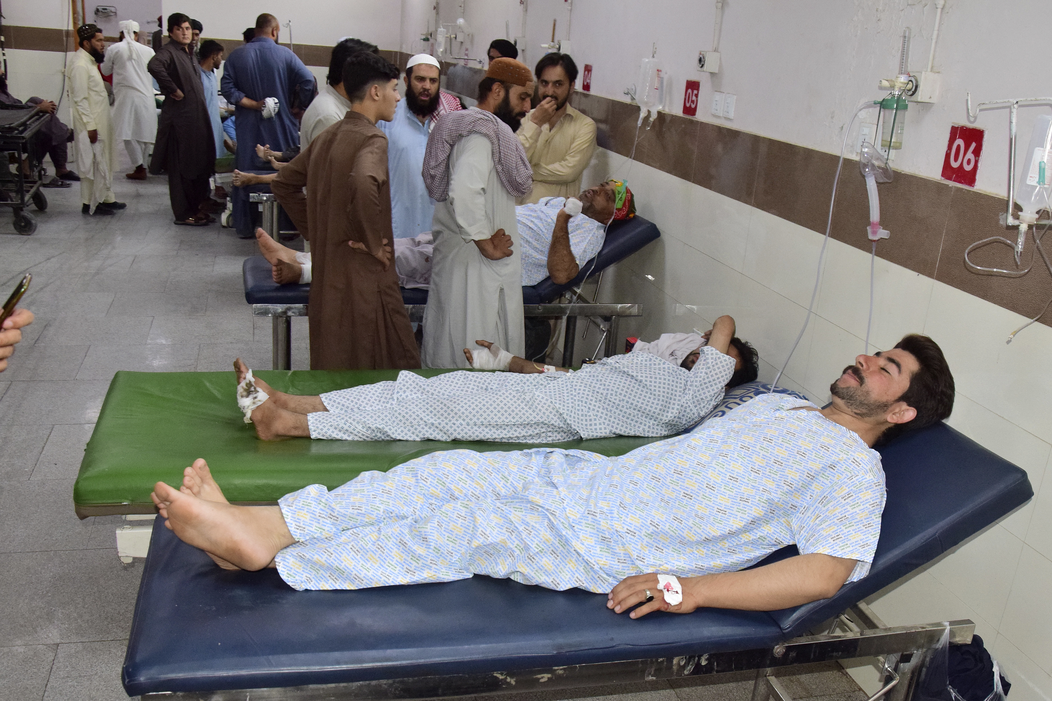 Two men lay on hospital beds