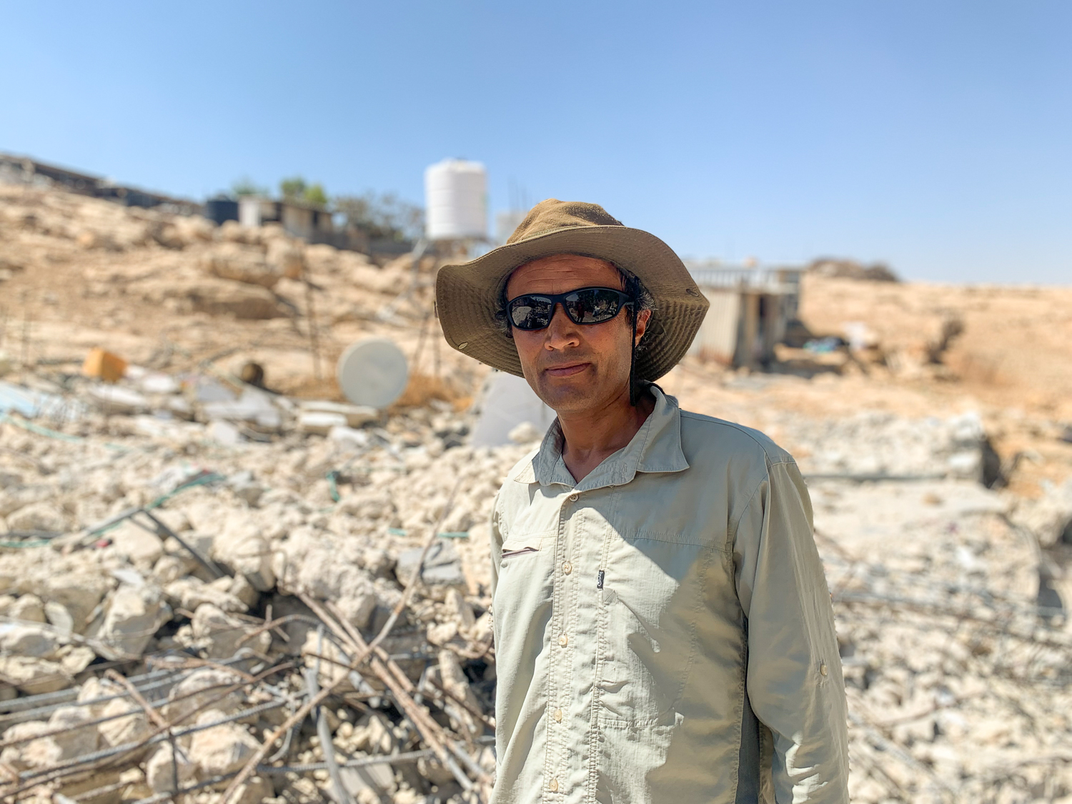 Man standing in front of demolished house