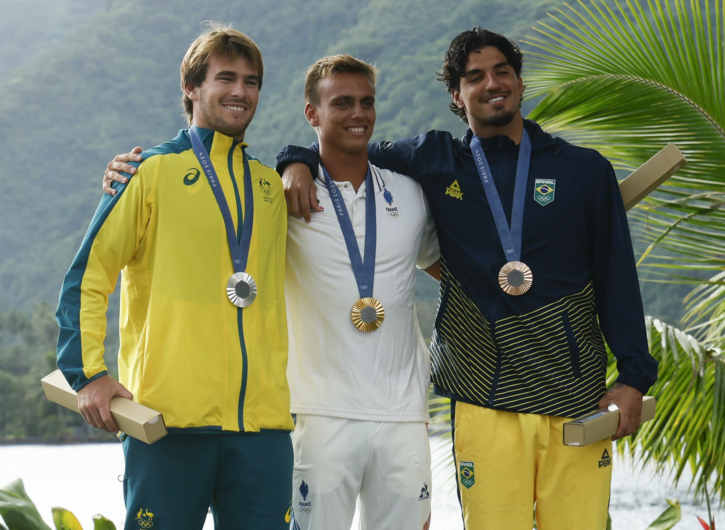 Three surfers receiving Olympic medal.