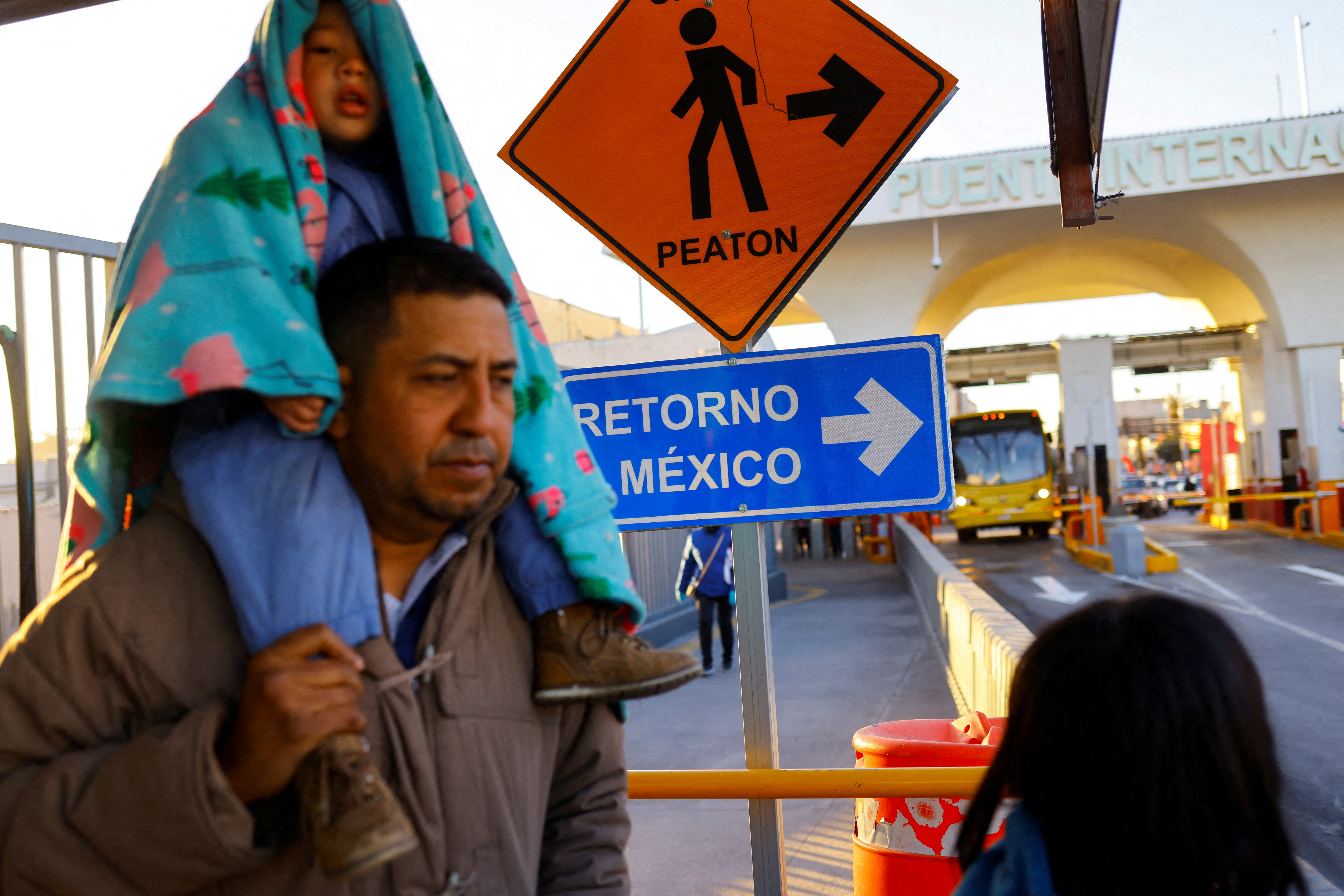 A Venezuelan asylum seeker and his son walks back into Mexico