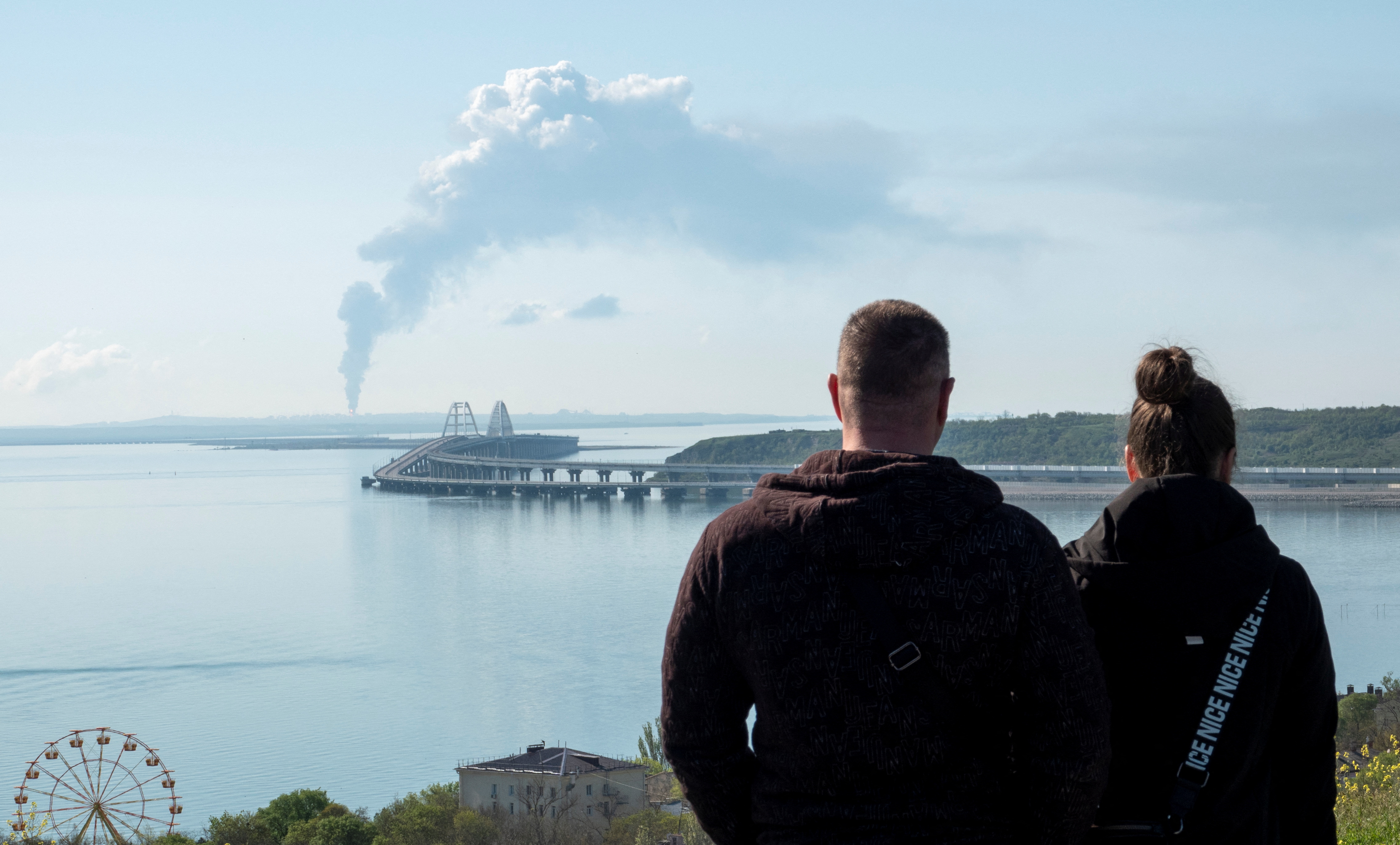 A view across the Kerch Strait shows smoke rising above a fuel depot near the Crimean bridge in the village of Volna in Russia's Krasnodar region as seen from a coastline in Crimea, May 3, 2023. REUTERS/Stringer