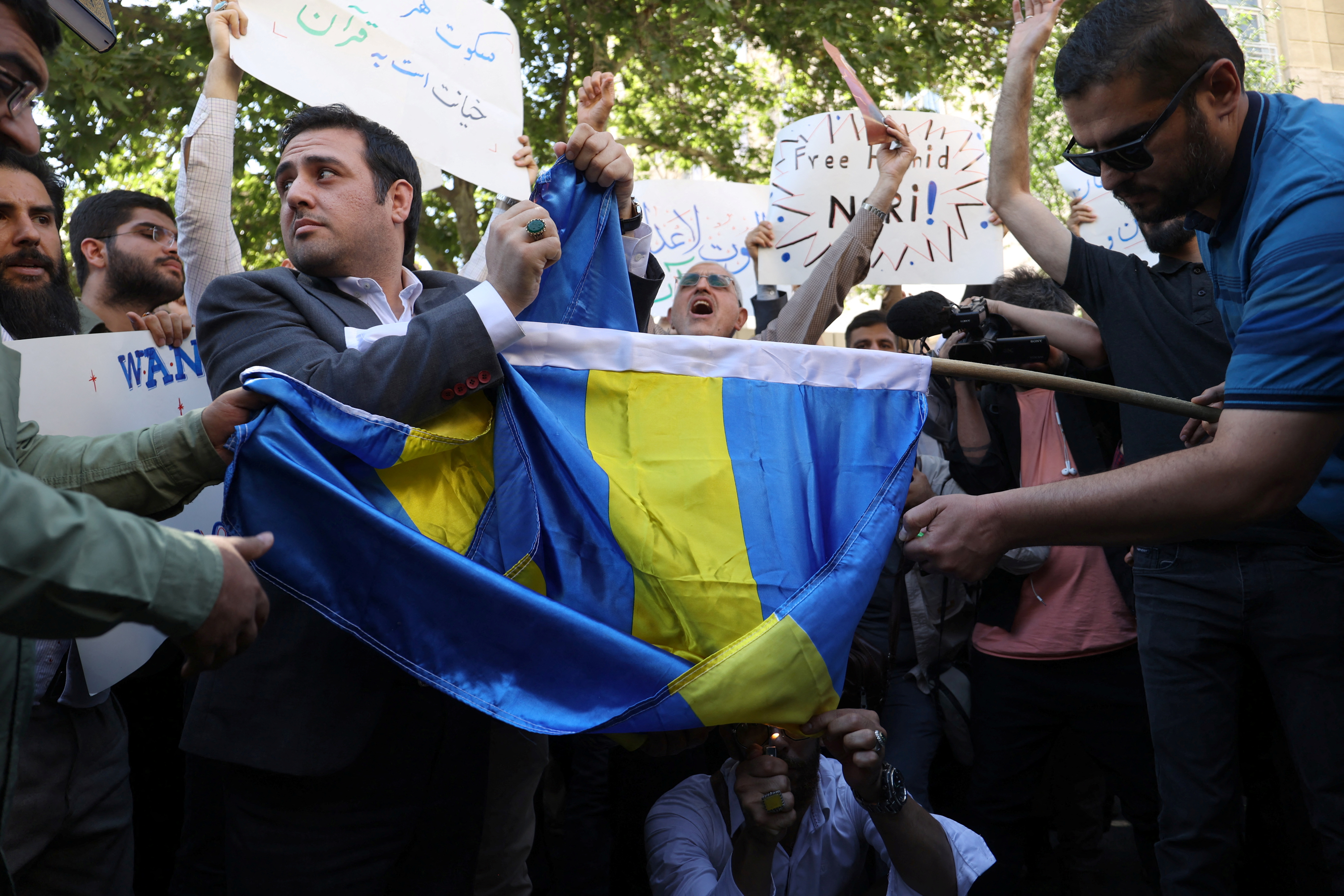 Demonstrators burn the Swedish flag during a protest against a man who burned a copy of the Quran outside a mosque in the Swedish capital Stockholm, in front of the Swedish Embassy in Tehran, Iran June 30, 2023. Majid Asgaripour/WANA (West Asia News Agency) via REUTERS ATTENTION EDITORS - THIS PICTURE WAS PROVIDED BY A THIRD PARTY.