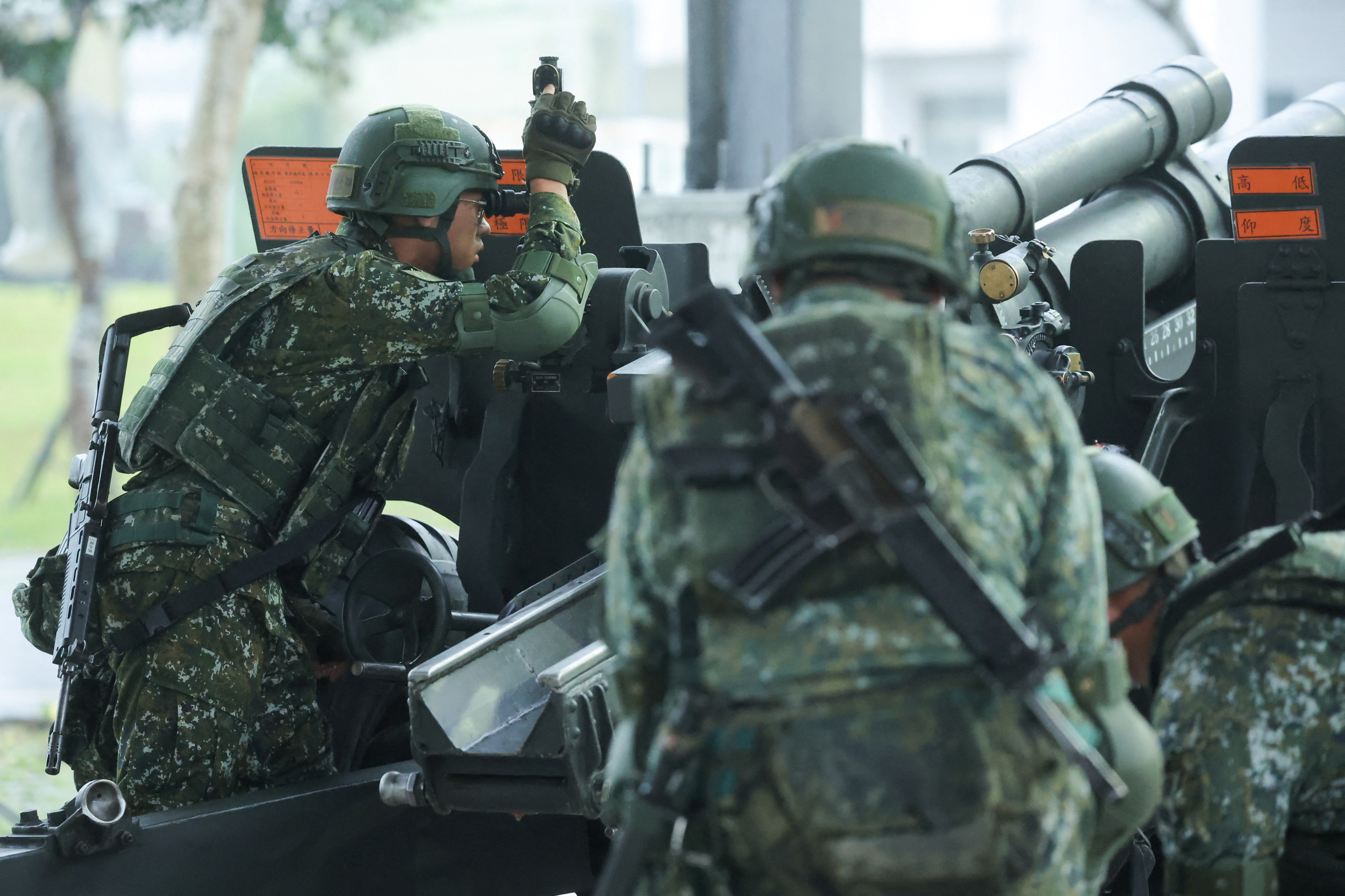 Taiwan soldiers loading a 105mm howitzer