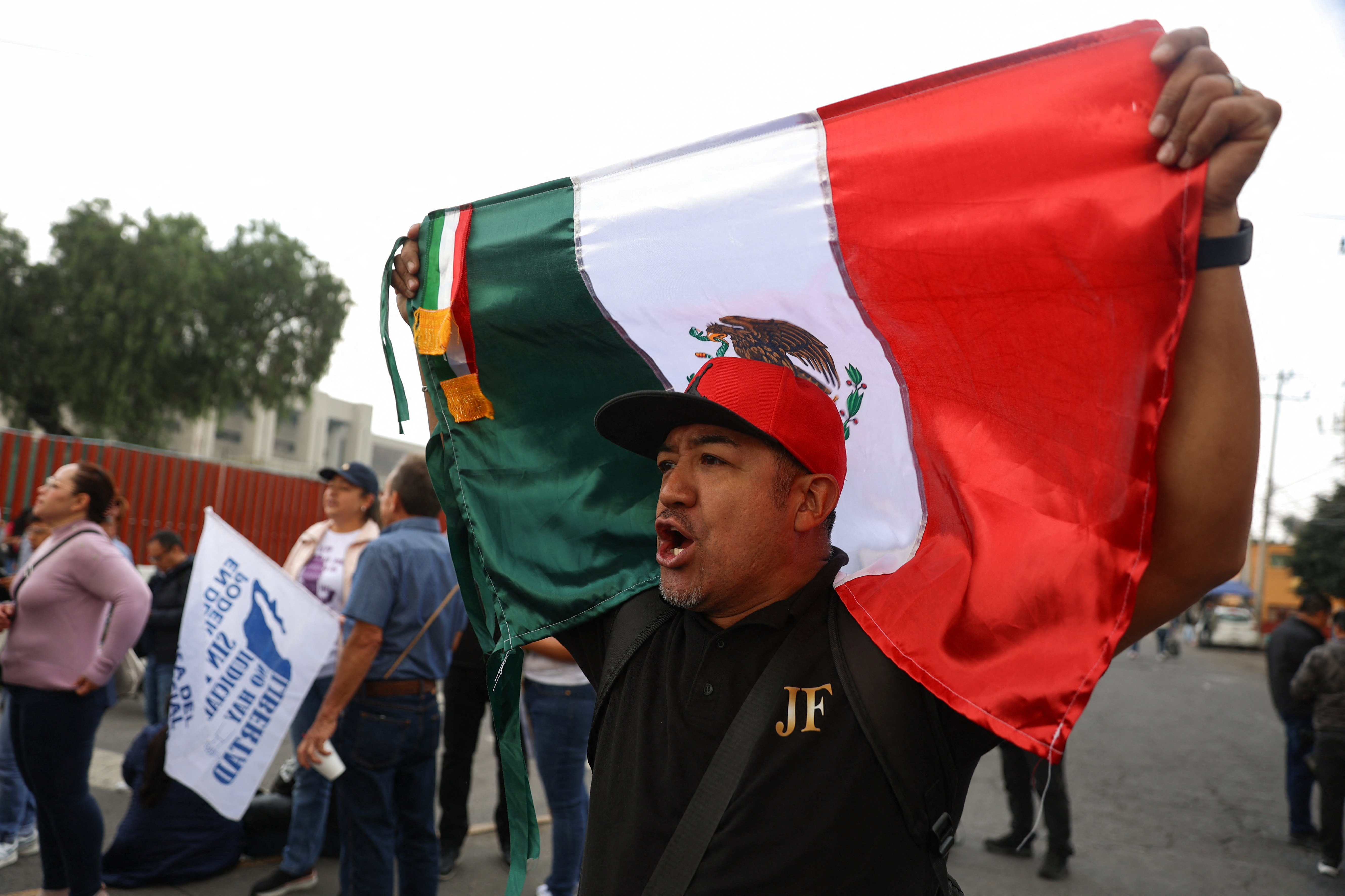A man holds a Mexican flag