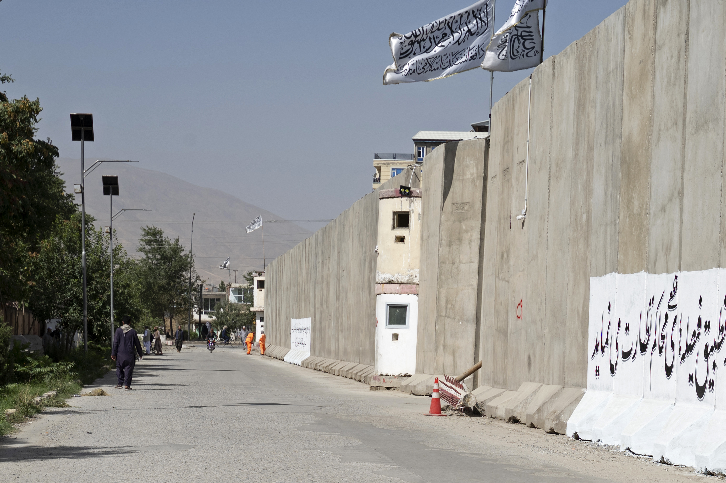 Afghan men walk near the site a day after a suicide bomber triggered explosives in front of the General Directorate for Monitoring and Follow-up of Decrees and Directives, in Kabul on September 3, 2024. - A suicide bomber triggered explosives in the Afghan capital on September 2, police said, killing six people and wounding 13 more. (Photo by Wakil KOHSAR / AFP)