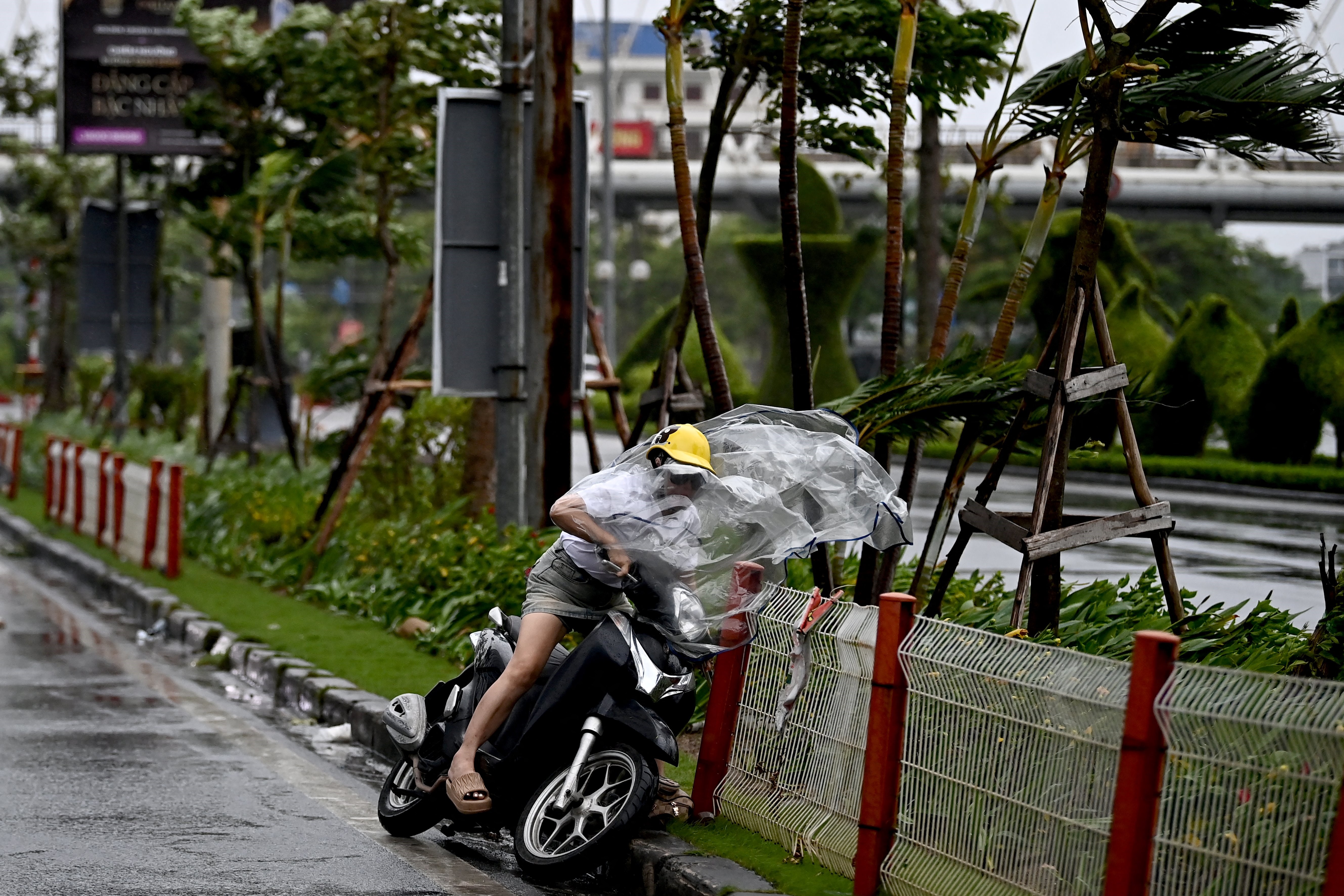 A woman riding a motorbike falls down from the wind of Typhoon Yagi in Hai Phong city on September 7, 2024. Super Typhoon Yagi threatened September 6 to be the strongest storm in over a decade to hit heavily populated areas of southern China, while tens of thousands of people also prepared to seek shelter in neighbouring Vietnam. (Photo by Nhac NGUYEN / AFP)