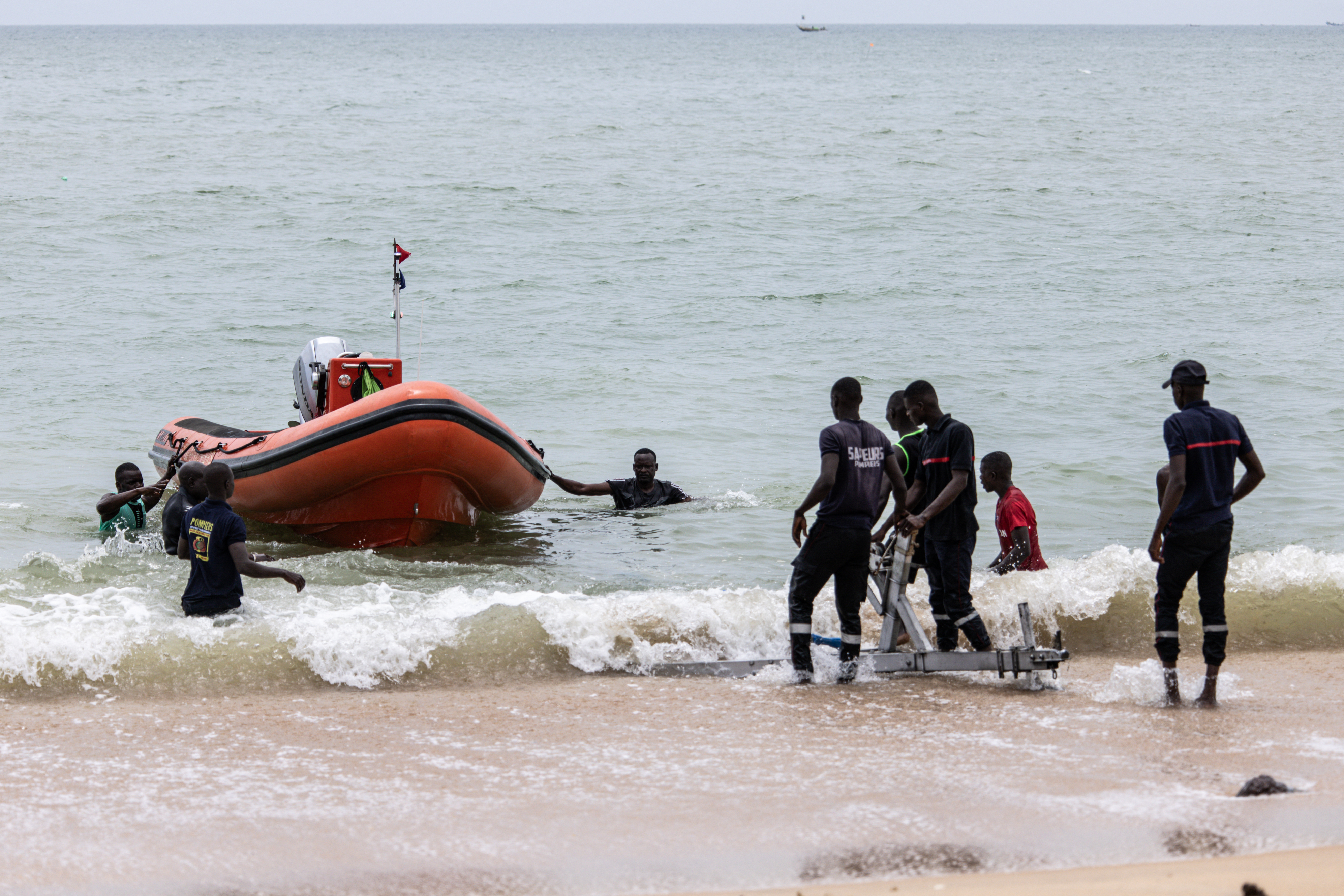 Members of a search and rescue team make their way to shore during a search to find survivors