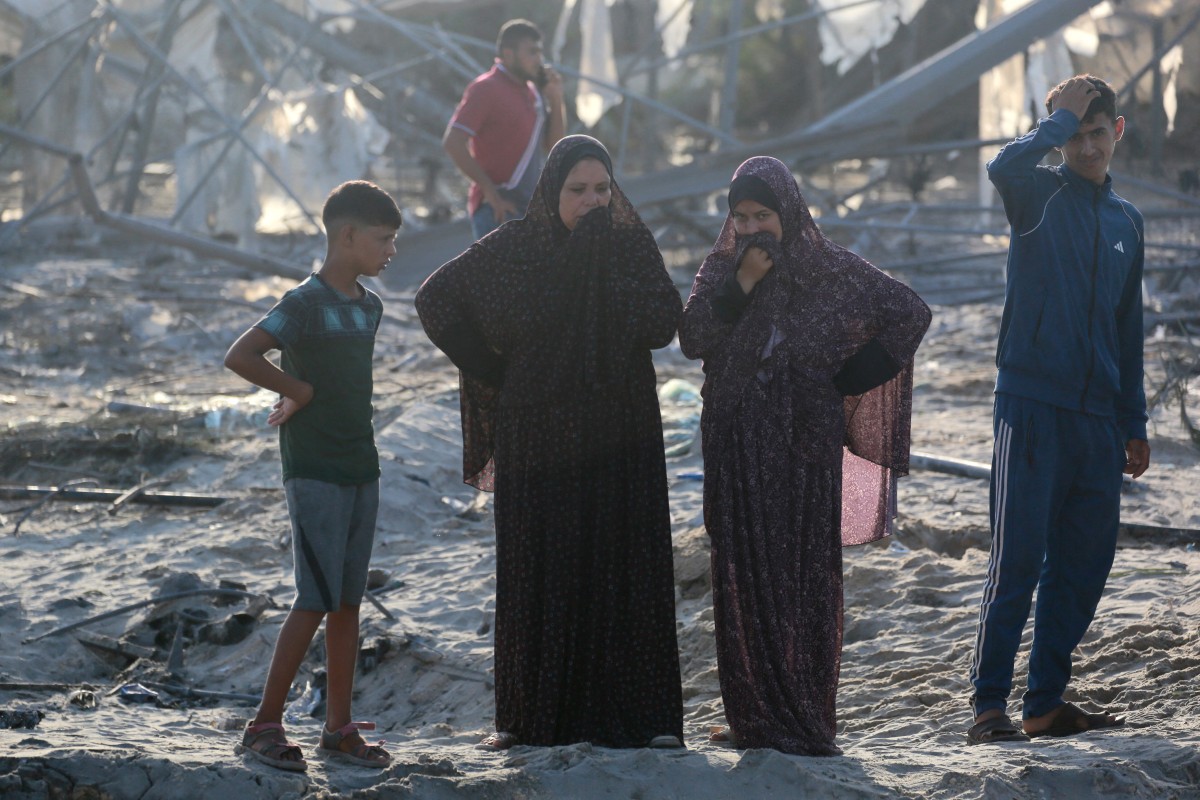 Palestinians inspect the damage at the site of Israeli strikes on a makeshift displacement camp in Mawasi Khan Yunis in the Gaza Strip