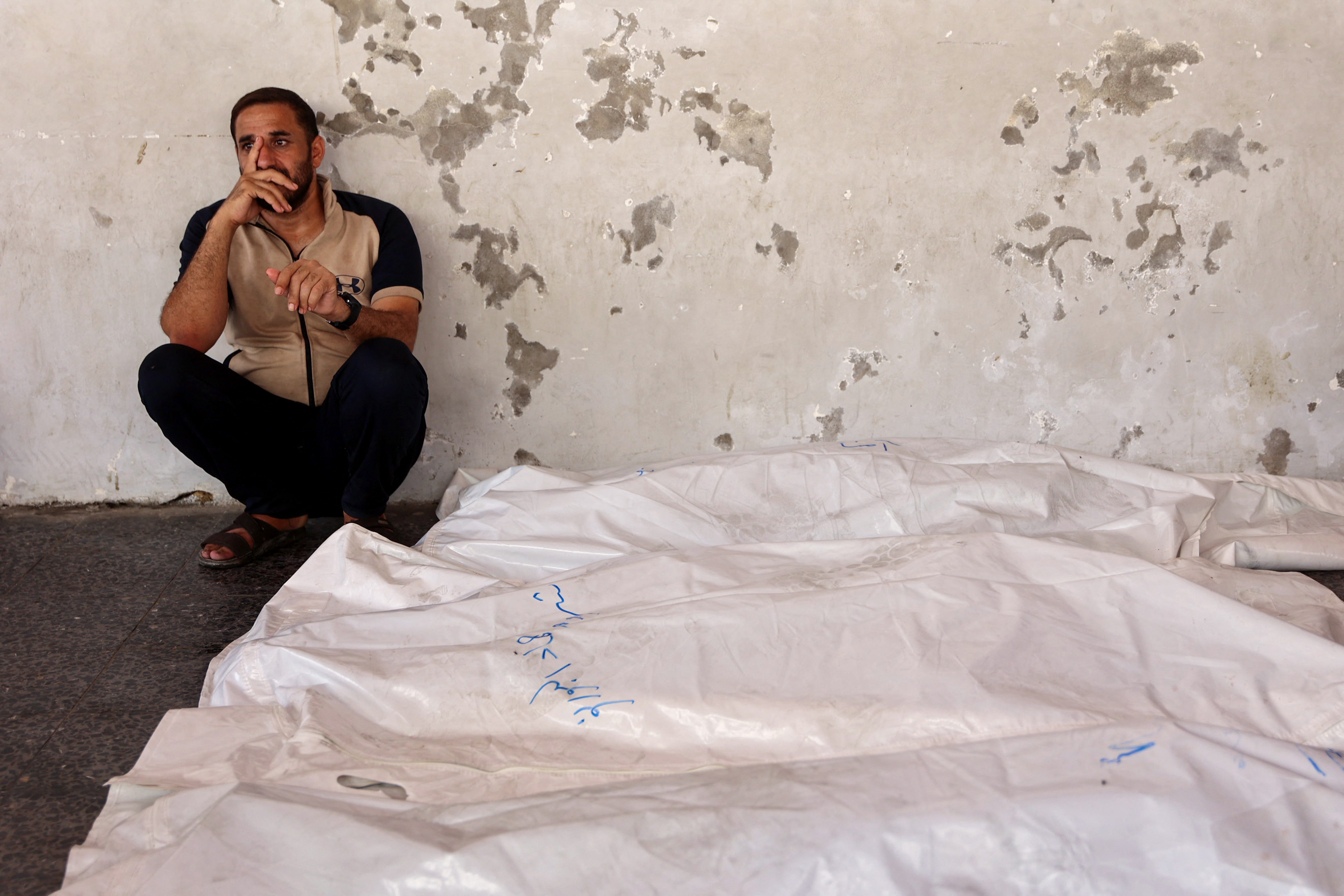 A man mourns by the bodies of five members of the Alborno family at Al-Ahli Arab hospital, also known as the Baptist hospital in Gaza City on September 15, 2024, after they were killed in reported Israeli bombardment of Zeitoun neighbourhood where they had gone earlier to check on their home