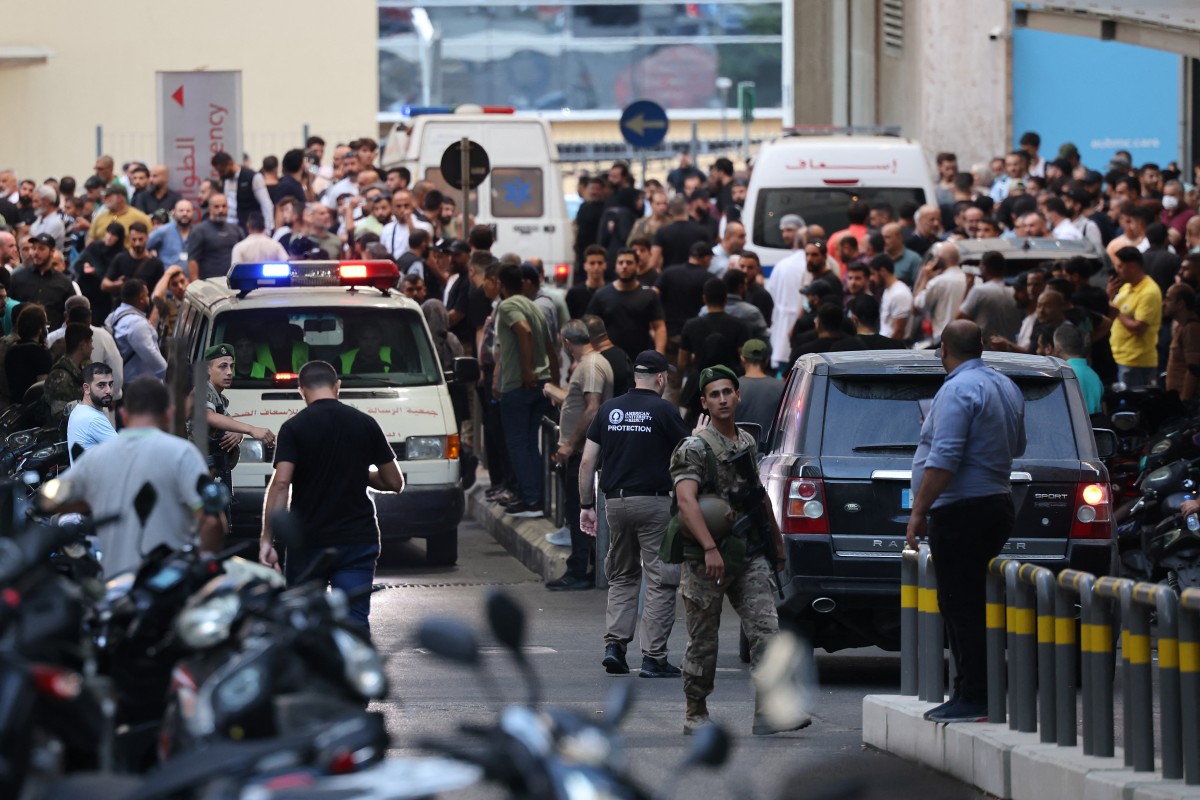 Ambulances are surrounded by people at the entrance of the American University of Beirut Medical Center, on September 17, 2024, after explosions hit locations in several Hezbollah strongholds around Lebanon amid ongoing cross-border tensions between Israel and Hezbollah fighters. - Hundreds of people were wounded when Hezbollah members' paging devices exploded simultaneously across Lebanon on September 17, in what a source close to the militant movement said was an "Israeli breach" of its communications. (Photo by Anwar AMRO / AFP)