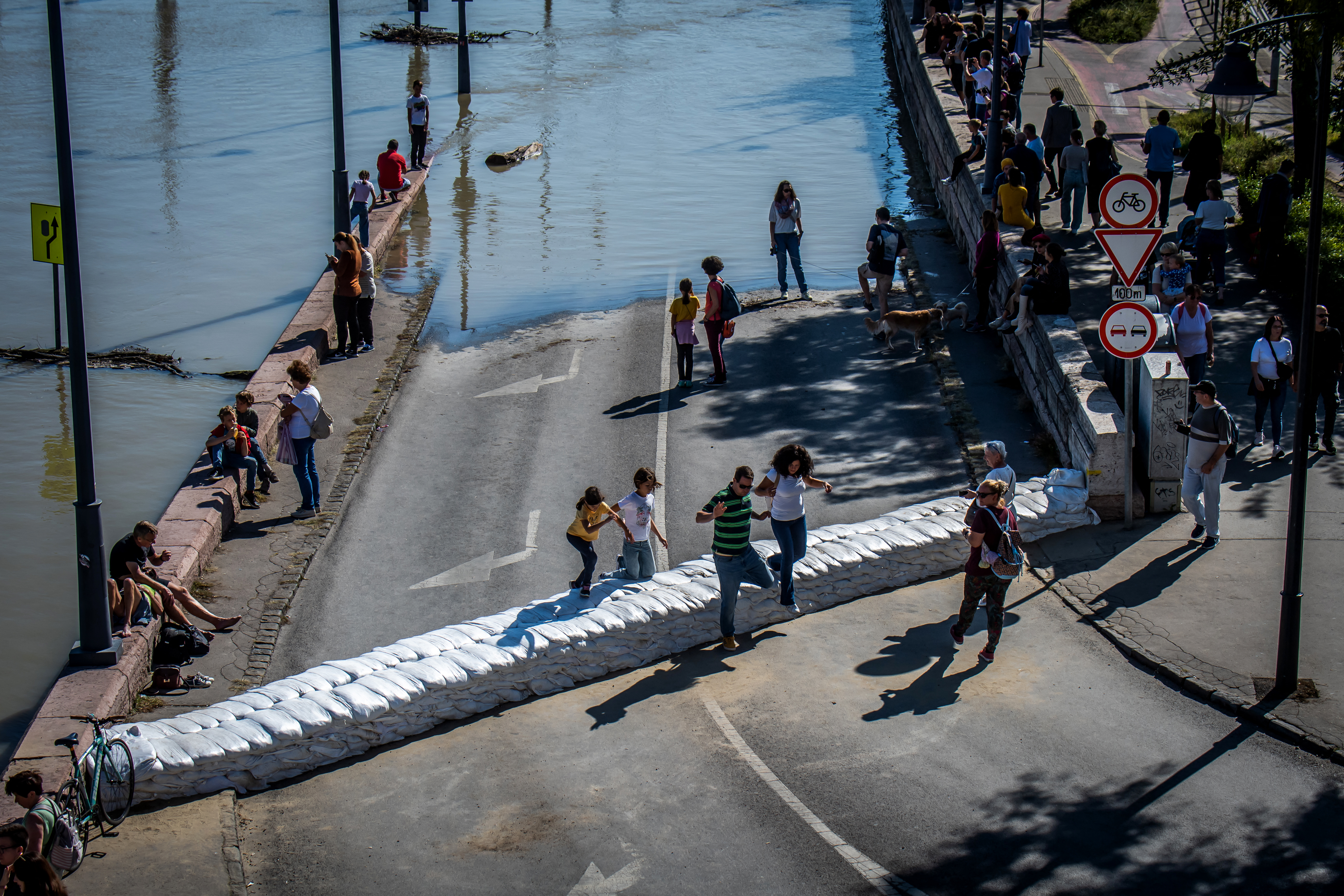 Onlookers walk over a barrier in Budapest after Storm Boris hit central Europe