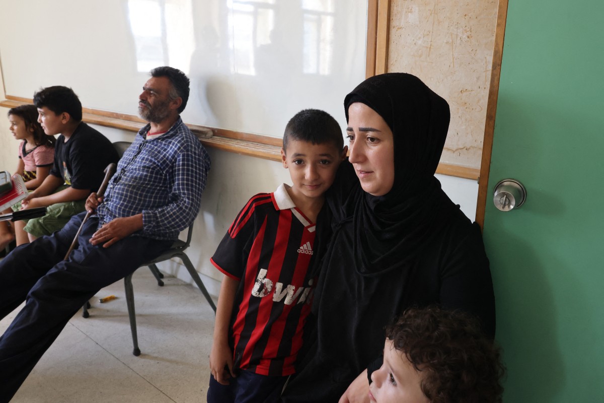 A family, who fled their village in southern Lebanon, take refuge at a school turned temporary shelter in the capital Beirut