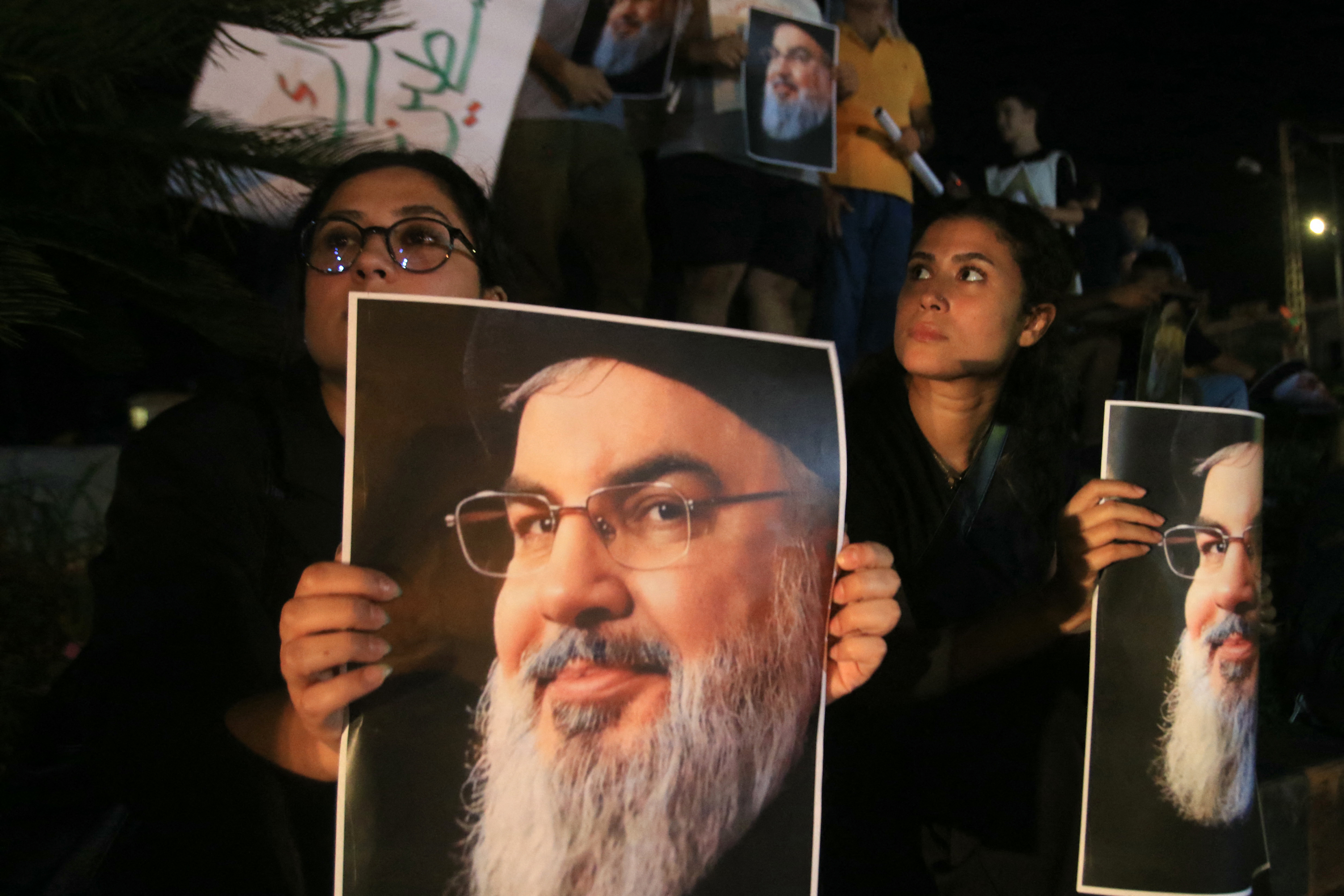 Demonstrators hold pictures of Hassan Nasrallah, late leader of the Lebanese group Hezbollah, during a protest vigil in the southern Lebanese city of Sidon on September 28, 2024. - Lebanon announced three days of mourning for Hassan Nasrallah on September 28, after a huge Israeli air strike in Beirut's southern suburbs the previous day killed the Hezbollah leader. (Photo by Mahmoud ZAYYAT / AFP)
