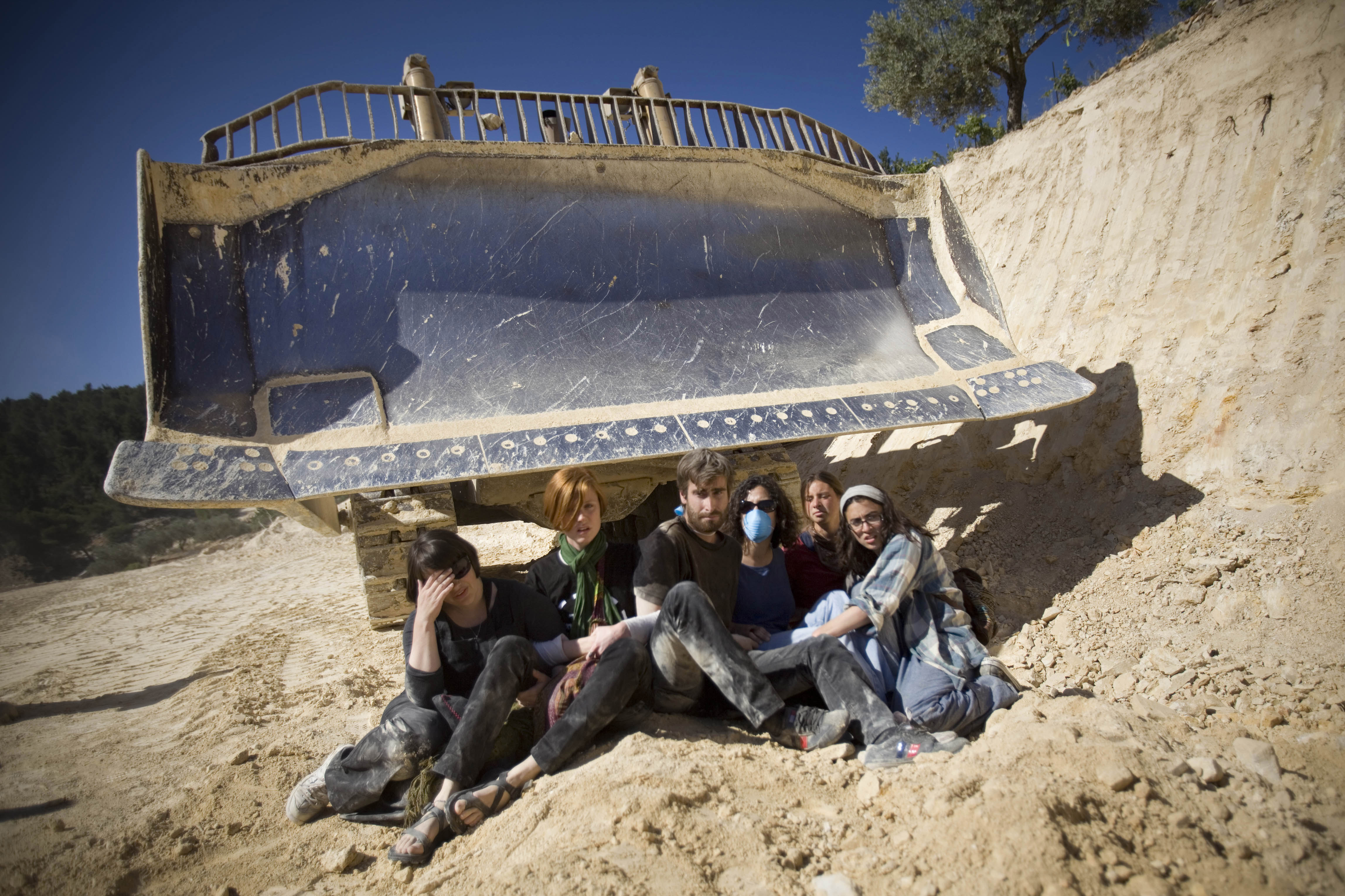 Israeli and international activists prevent a bulldozer to work during a protest.