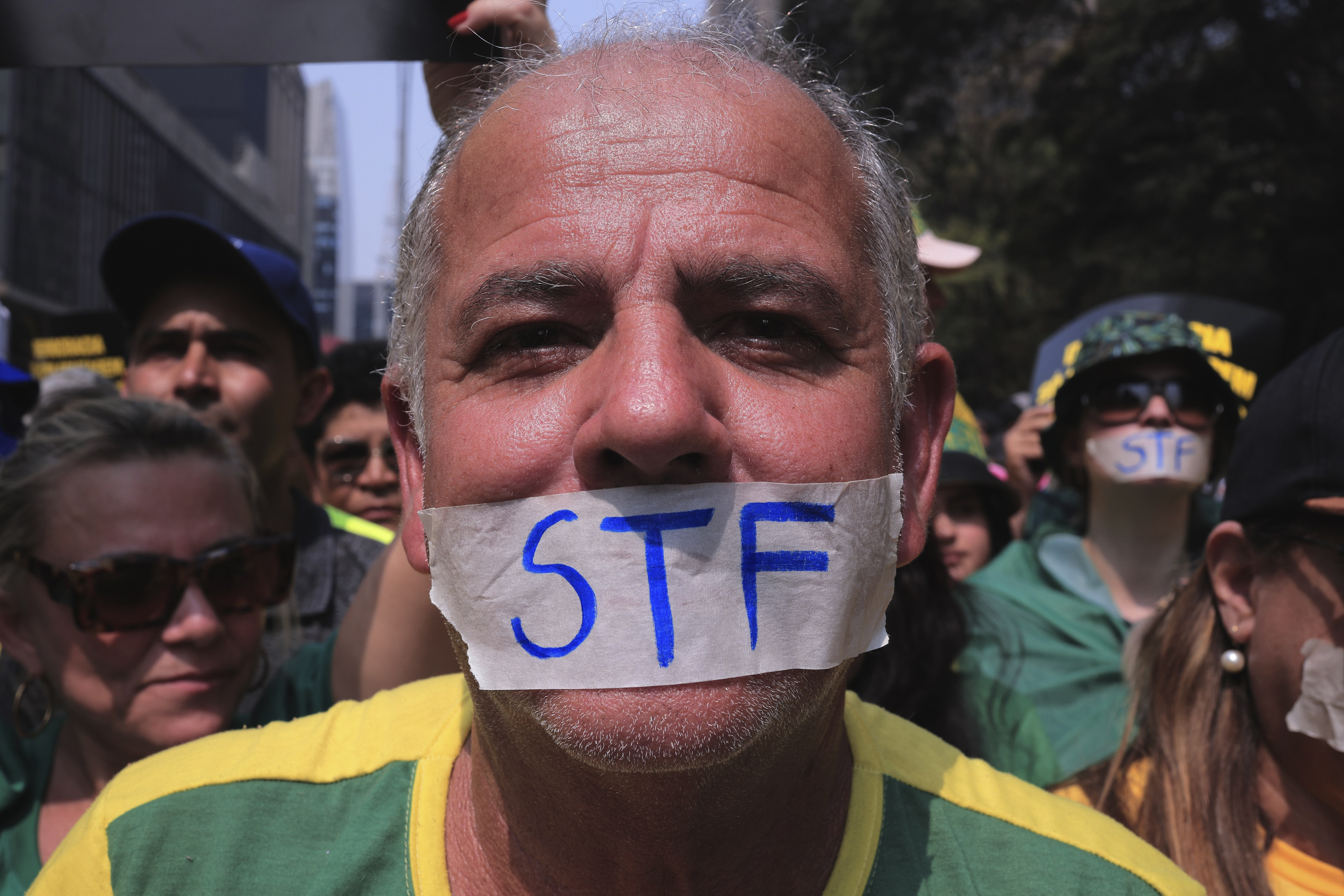 A protester has duct tape over his mouth that reads: "STF"