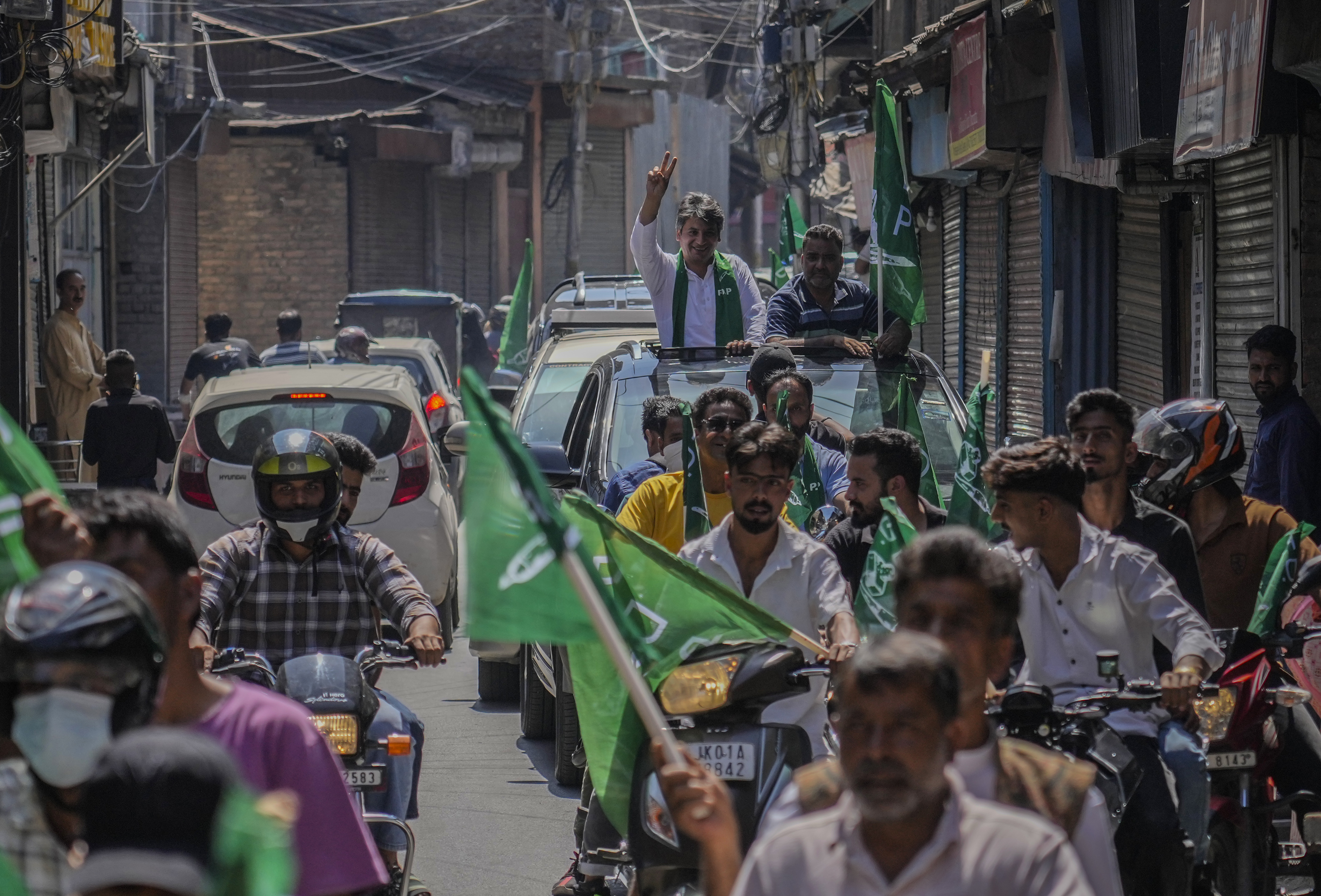 Peoples Democratic Party (PDP) candidate Arif Laigroo, flashes the victory sign during a road show ahead of elections in Srinagar, Indian-controlled Kashmir Sunday, Sept. 15, 2024. (AP Photo/Mukhtar Khan)