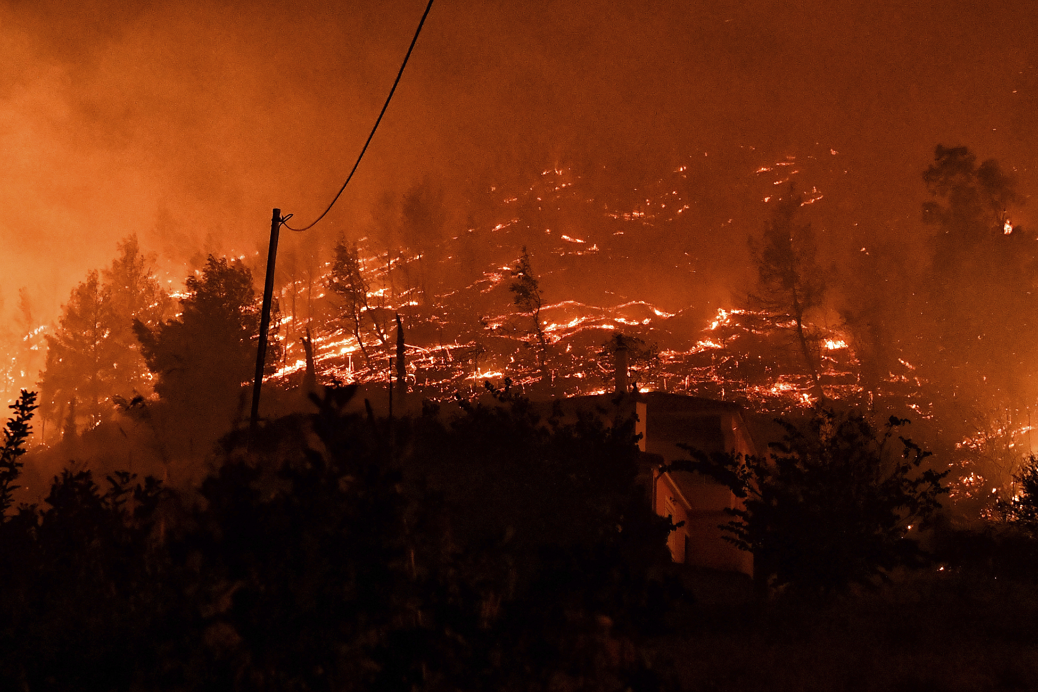 A wildfire burns a forest near the village of Kallithea as fanned by strong winds raged uncontrolled despite the attempts of hundreds of firefighters to stop it, some 149 kilometers (93 miles) west of Athens, Greece, in the region of Corinthia, late Sunday, Sept. 29
