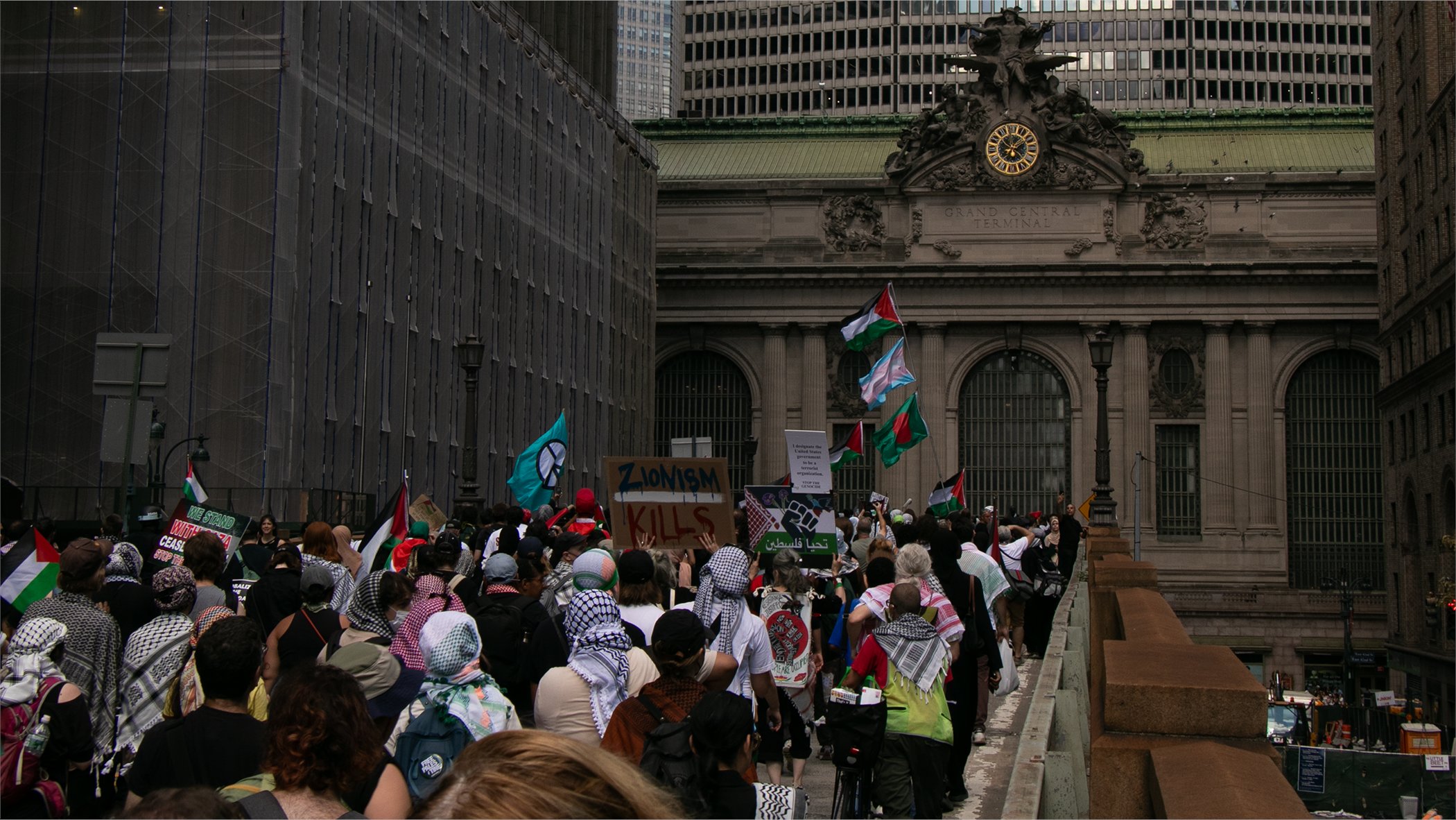 Protesters go towards Grand Central Station, an old train station with a clock embedded in its facade