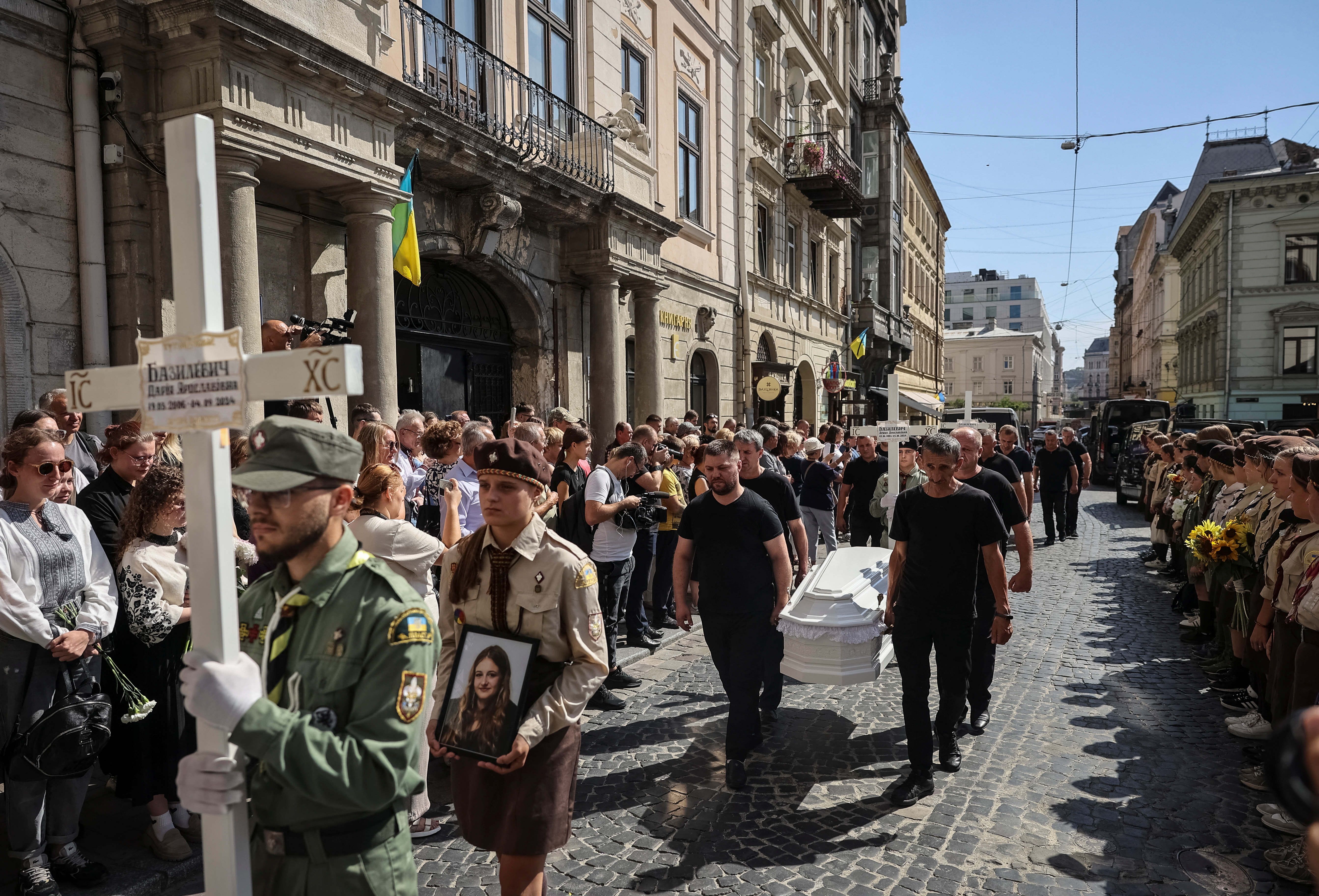 People attend a funeral procession for Yevhenia Bazylevych and her three daughters, killed during the Russian missile attack on September 4