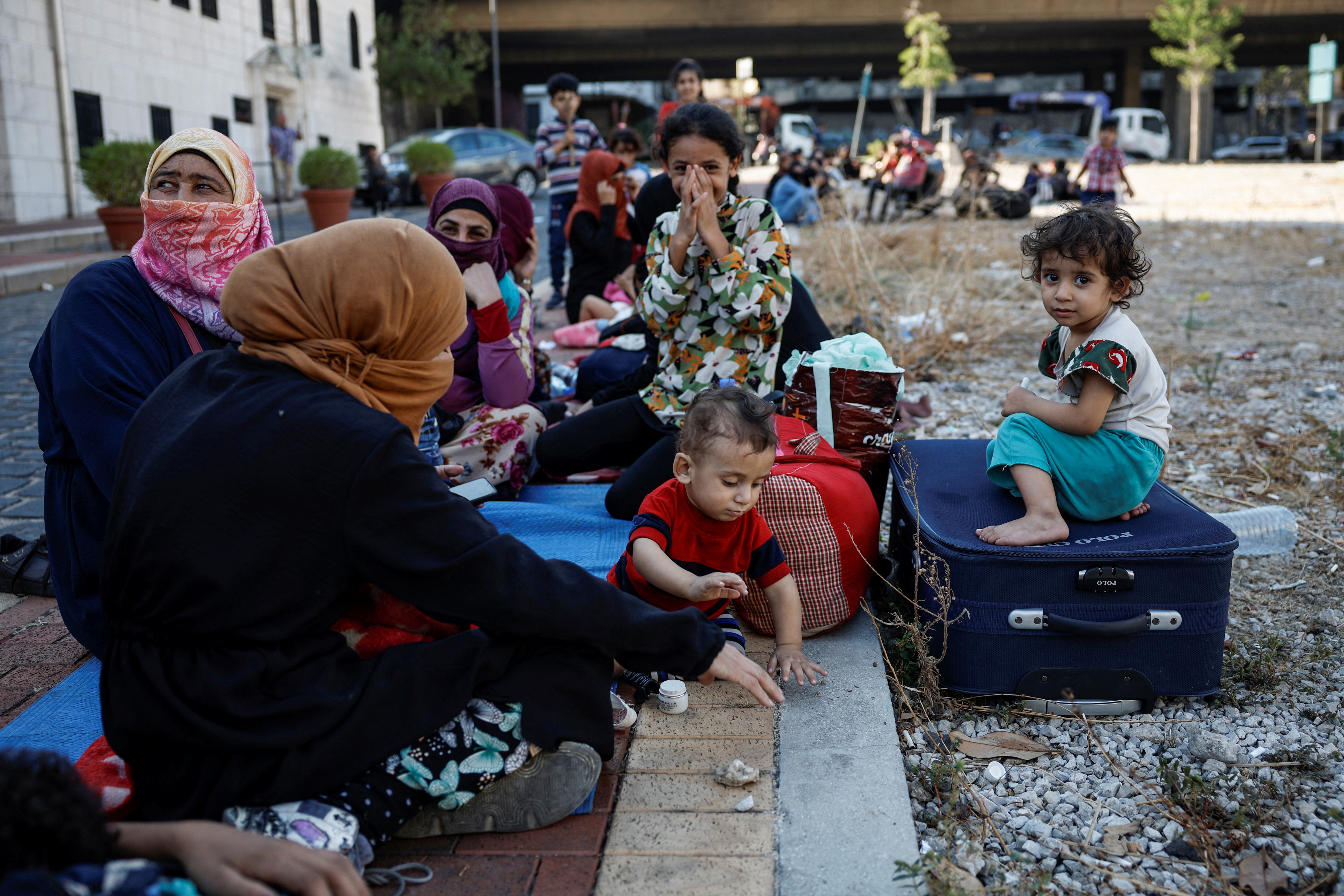 Displaced families gather near a church after spending the night there, fleeing the overnight Israeli strikes in Beirut, Lebanon September 28, 2024. [Louisa Gouliamaki/Reuters]