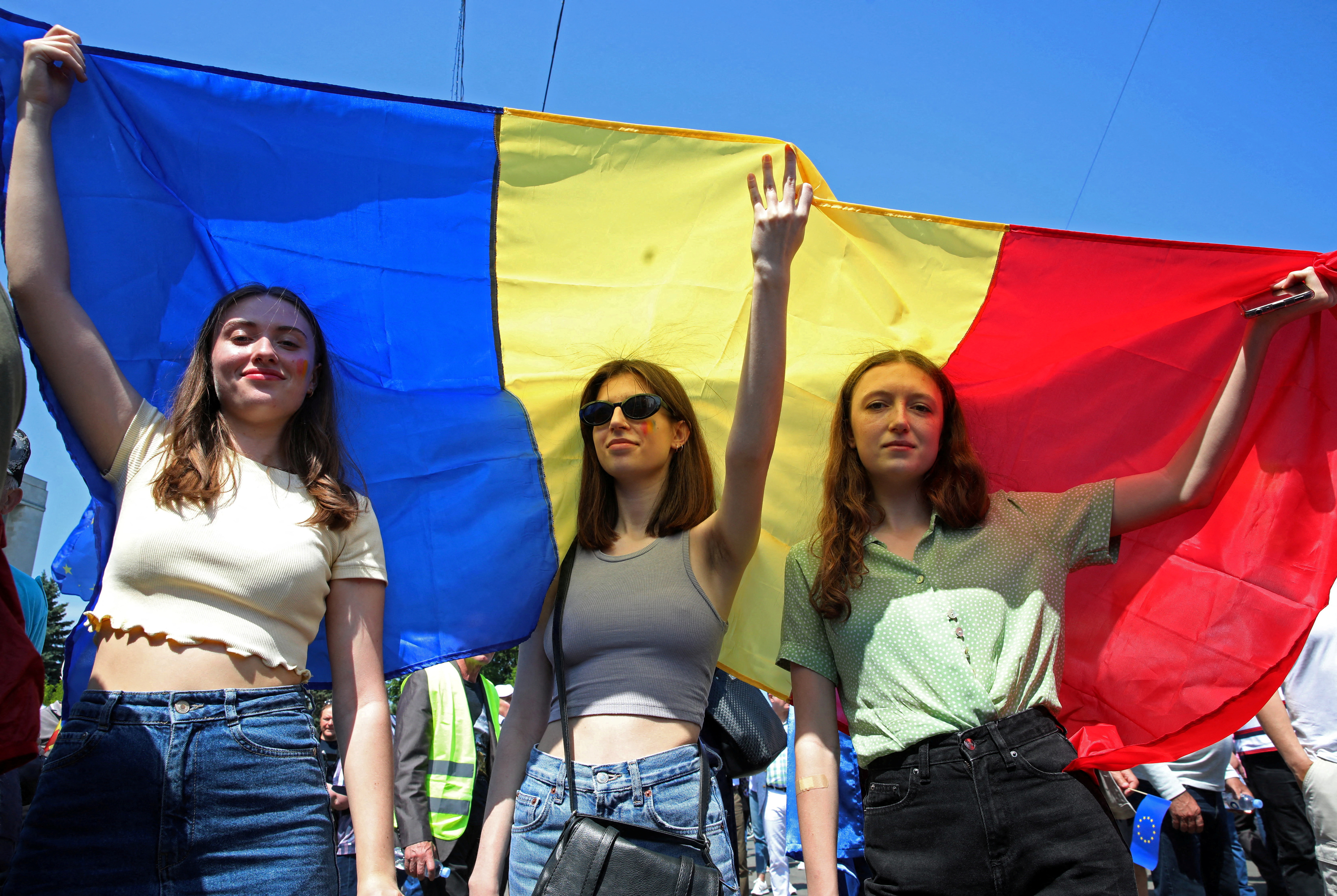 Women hold a Moldovan flag during a rally to support a European path for the country, in Chisinau, Moldova, May 21, 2023. REUTERS/Vladislav Culiomza