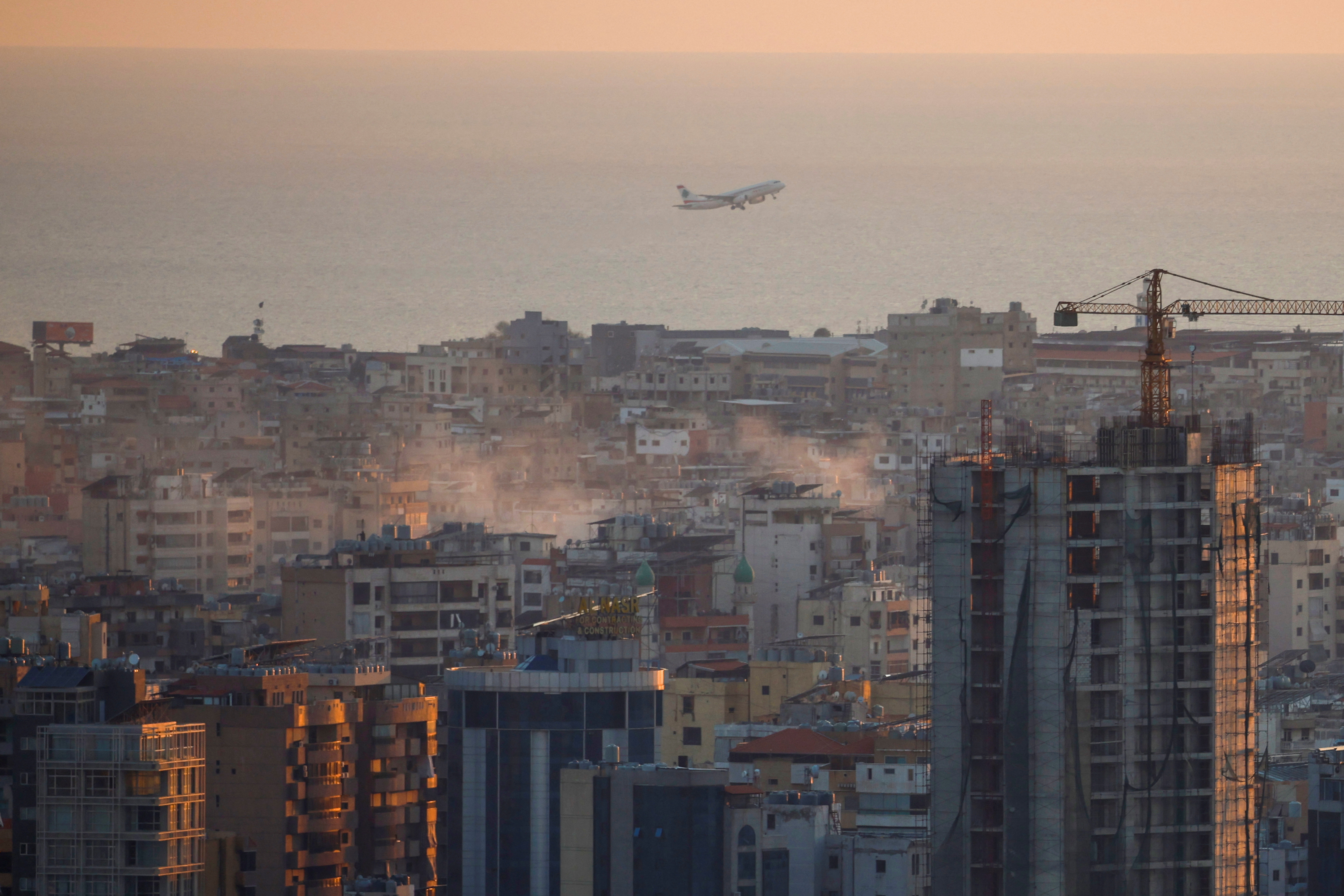 A plane takes off from Beirut's Rafic Hariri International Airport, as smoke from Israeli strikes billows over southern suburbs, amid the ongoing hostilities between Hezbollah and Israeli forces, in Beirut, Lebanon, October 5, 2024. REUTERS/Louisa Gouliamaki