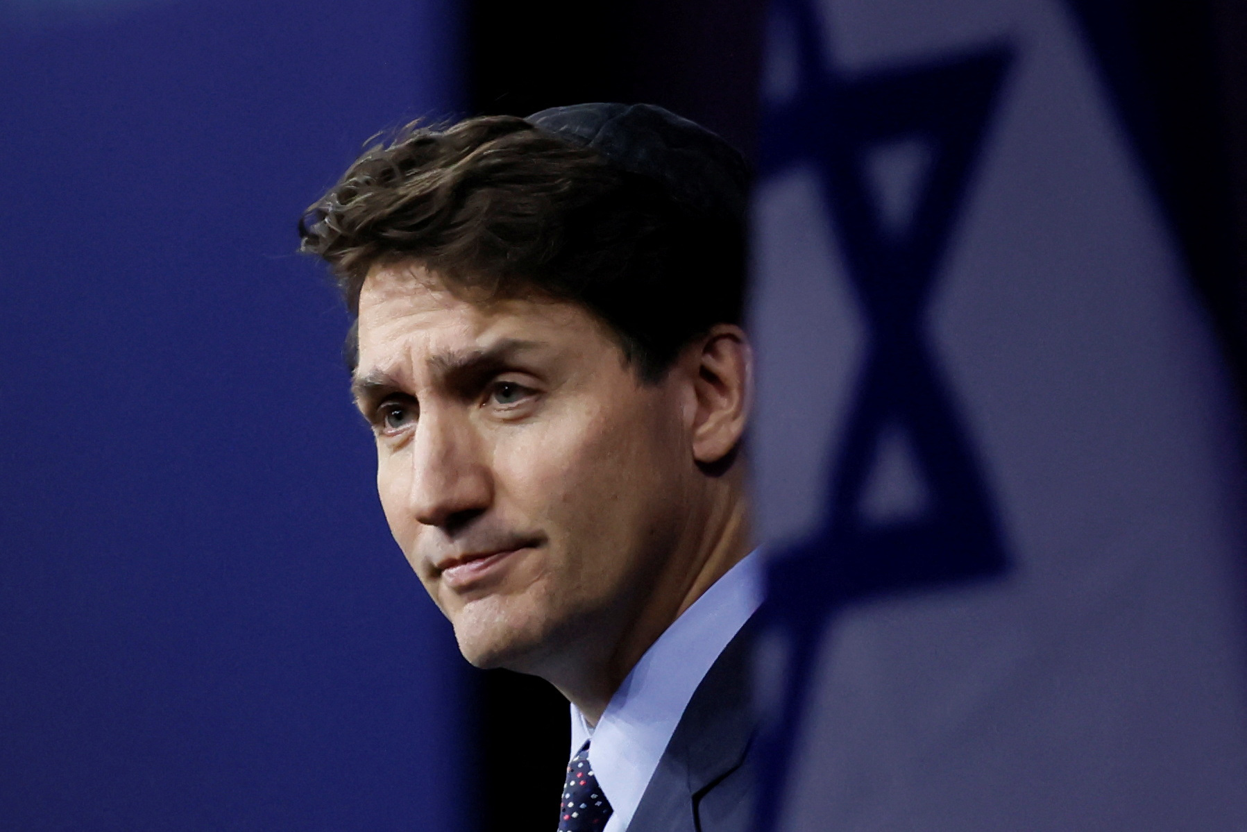 Justin Trudeau next to an Israeli flag at an event commemorating October 7