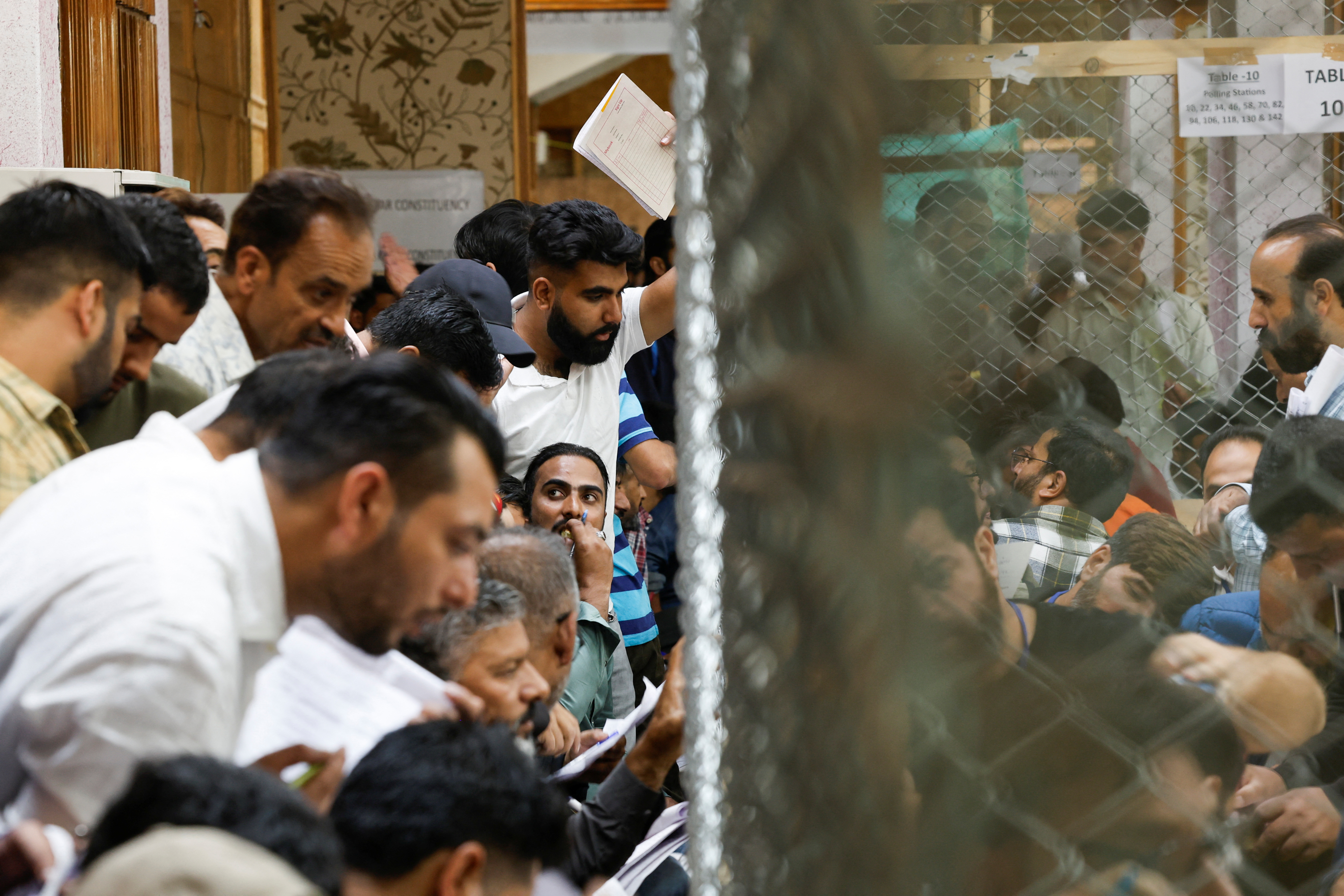 Election staff members count postal ballots as polling agents look on inside a vote counting centre in Srinagar, October 08, 2024.
