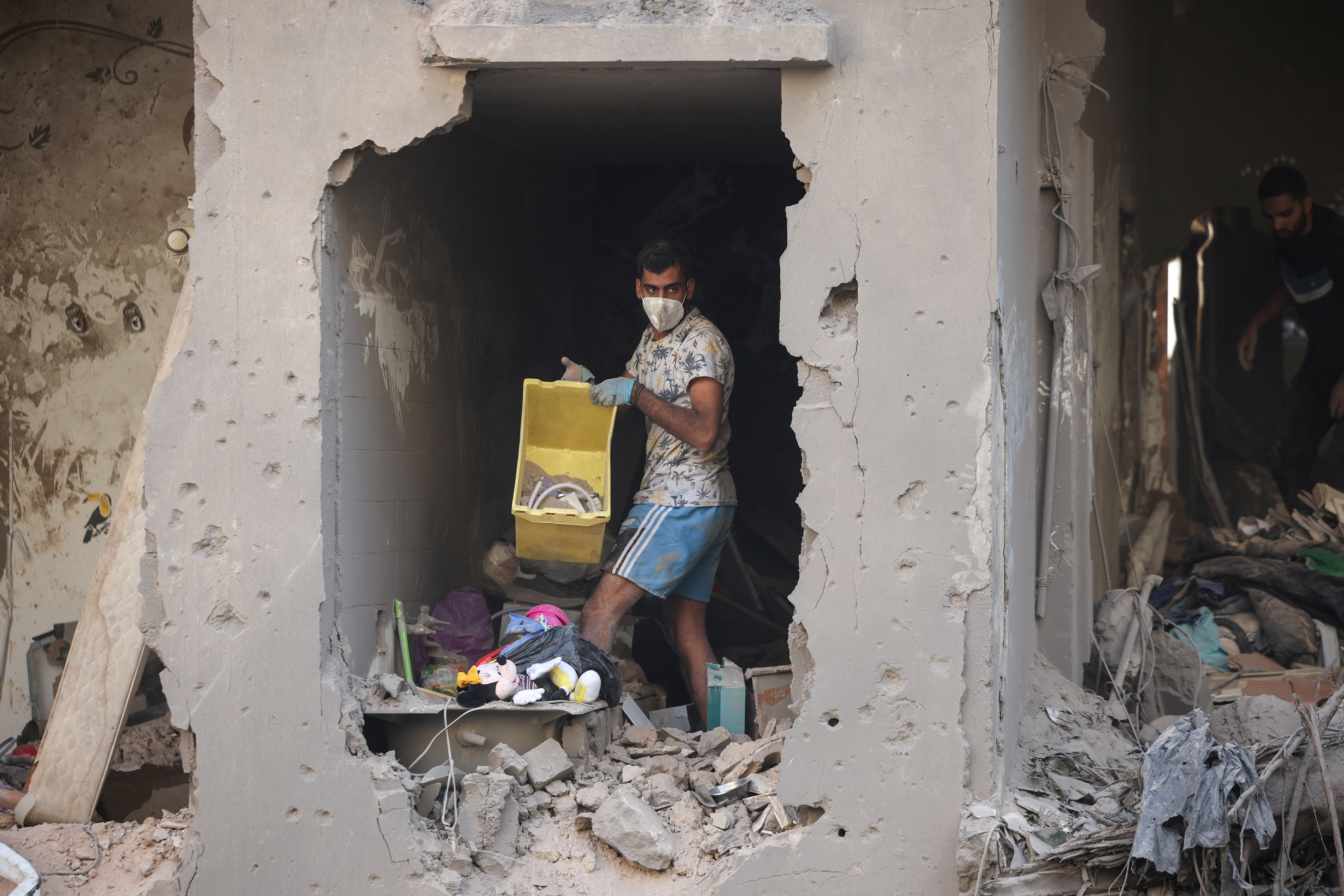 Relatives of Ahmed Al-Khatib clean rubble in their damaged apartment at the strike site in Beirut, Lebanon, October 11