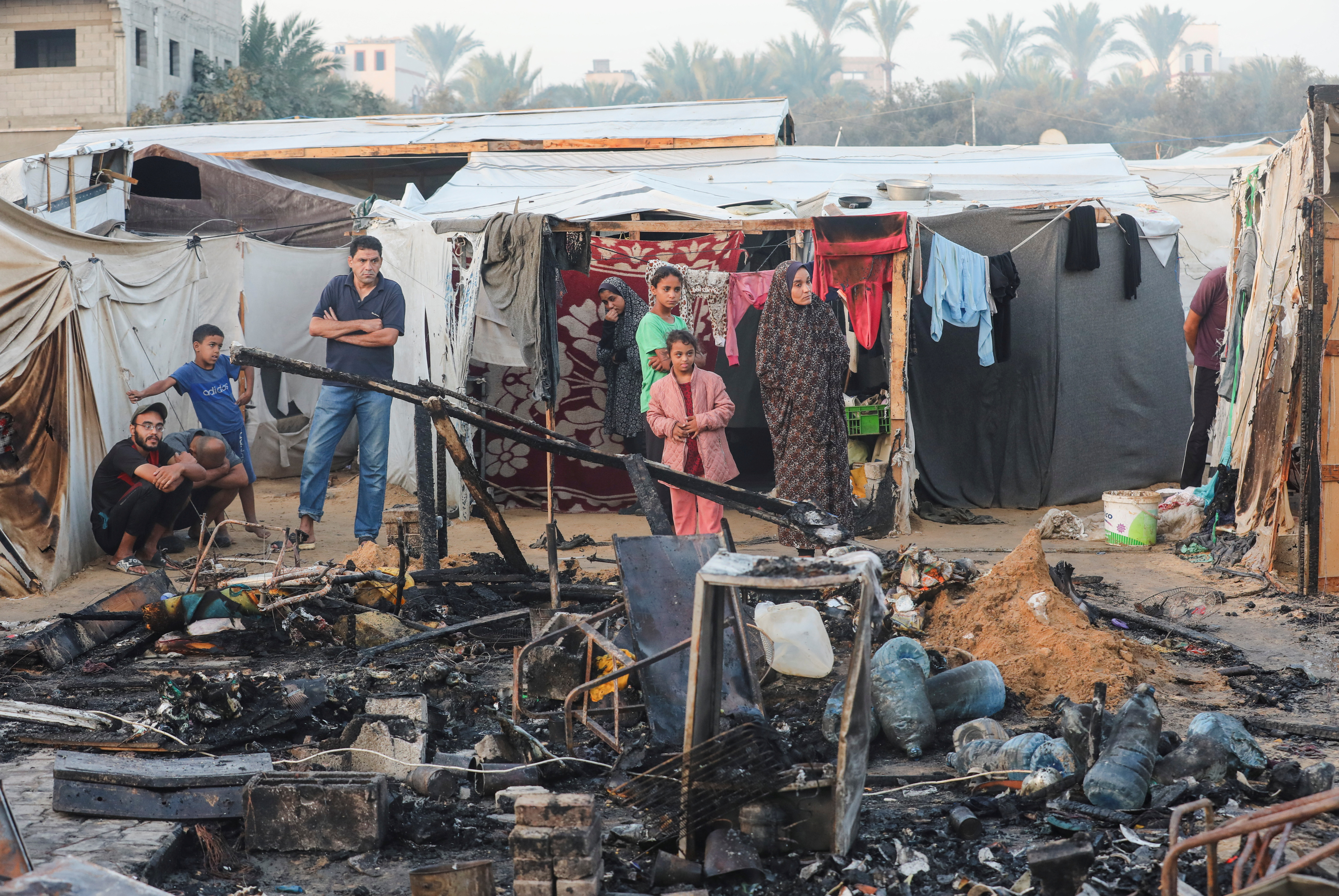 Palestinians survey the damage at the site of an Israeli strike on tents sheltering displaced people, amid the Israel-Hamas conflict, at Al-Aqsa Martyrs hospital in Deir Al-Balah in the central Gaza Strip, October 14, 2024. REUTERS/Ramadan Abed