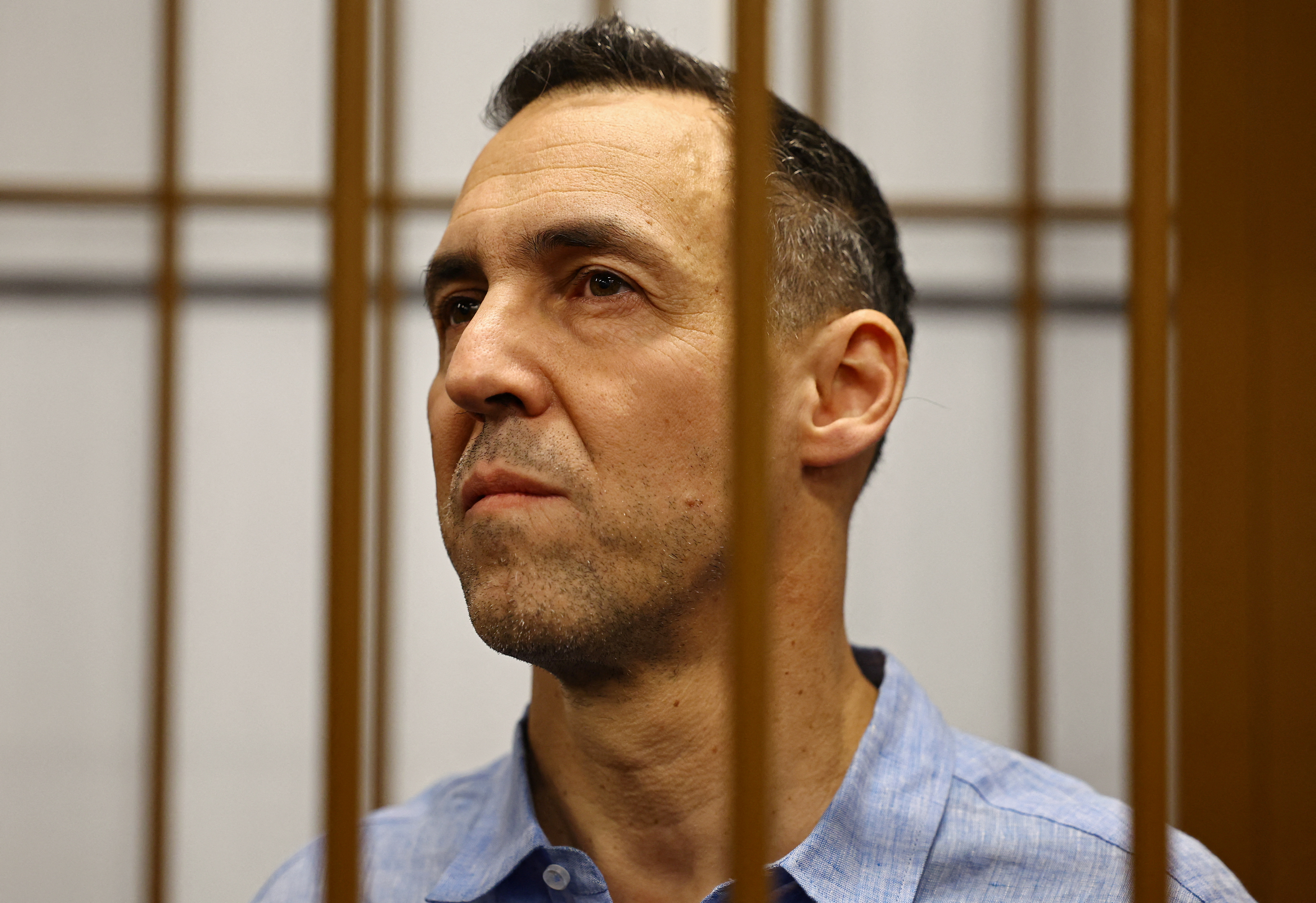Laurent Vinatier pictured in the dock in a Moscow court. He is wearing a pale blue shirt. He has a serious expression.
