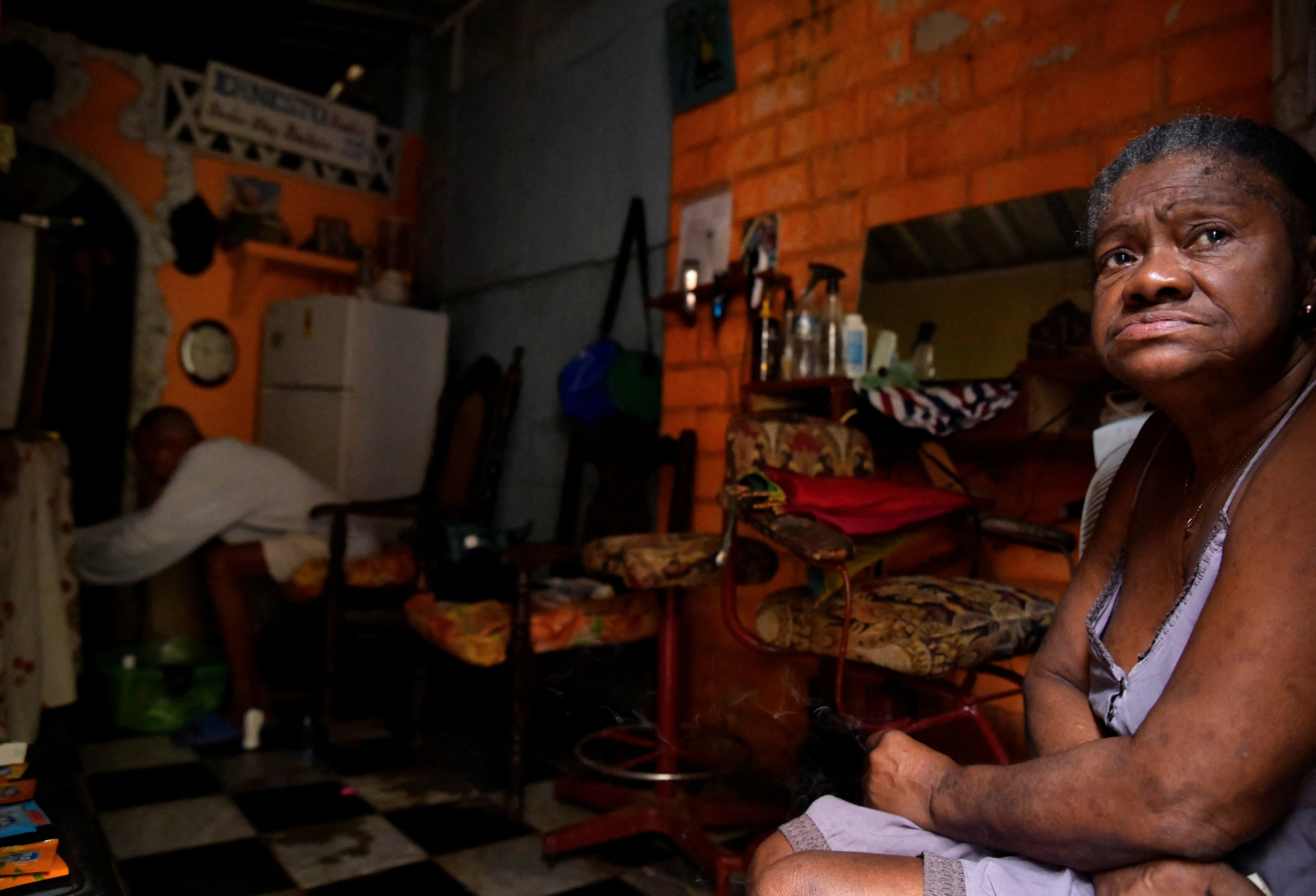 Residents in Cuba sit in the doorway of a home during a blackout.