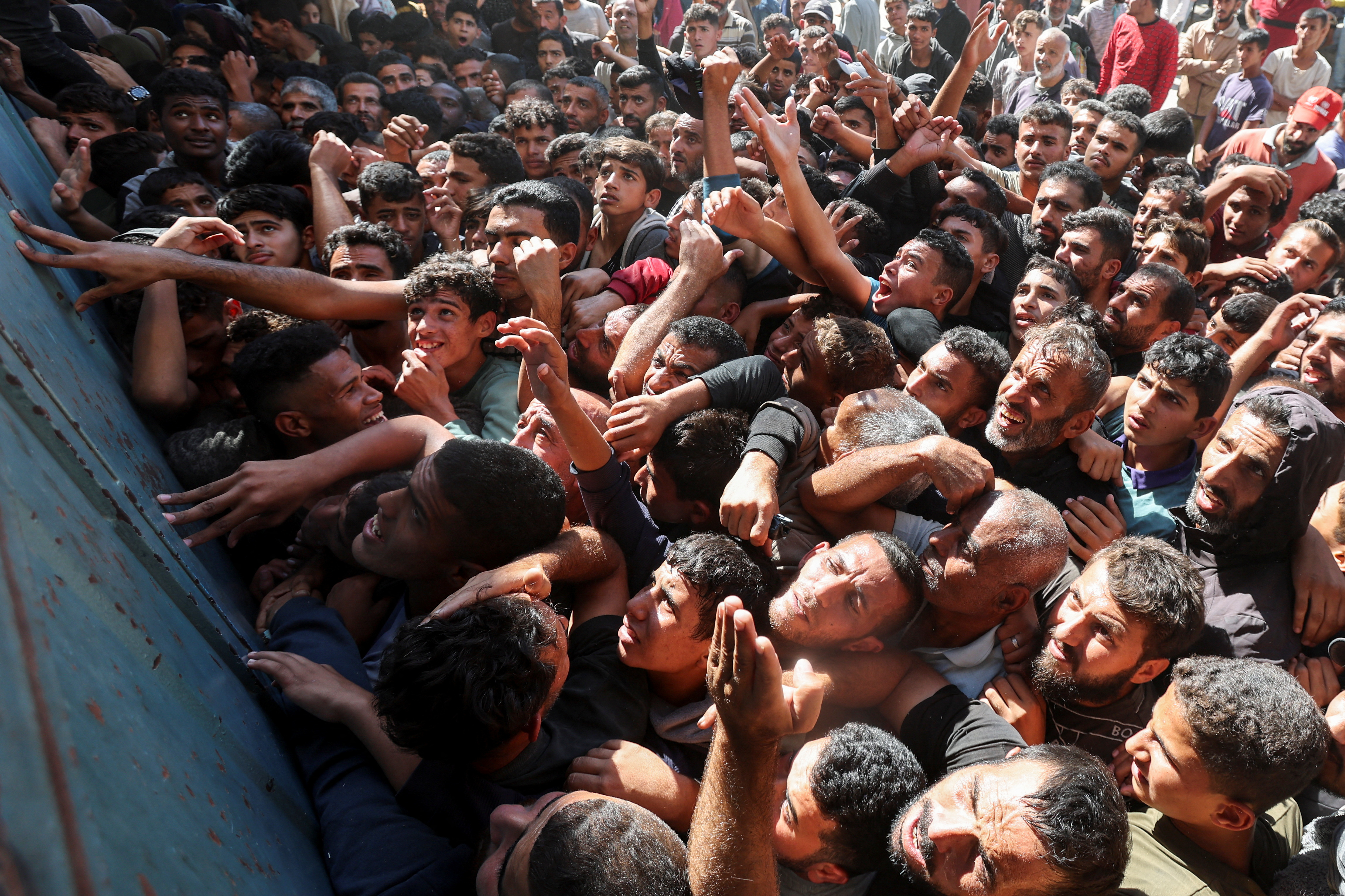 Palestinians gather to buy bread from a bakery