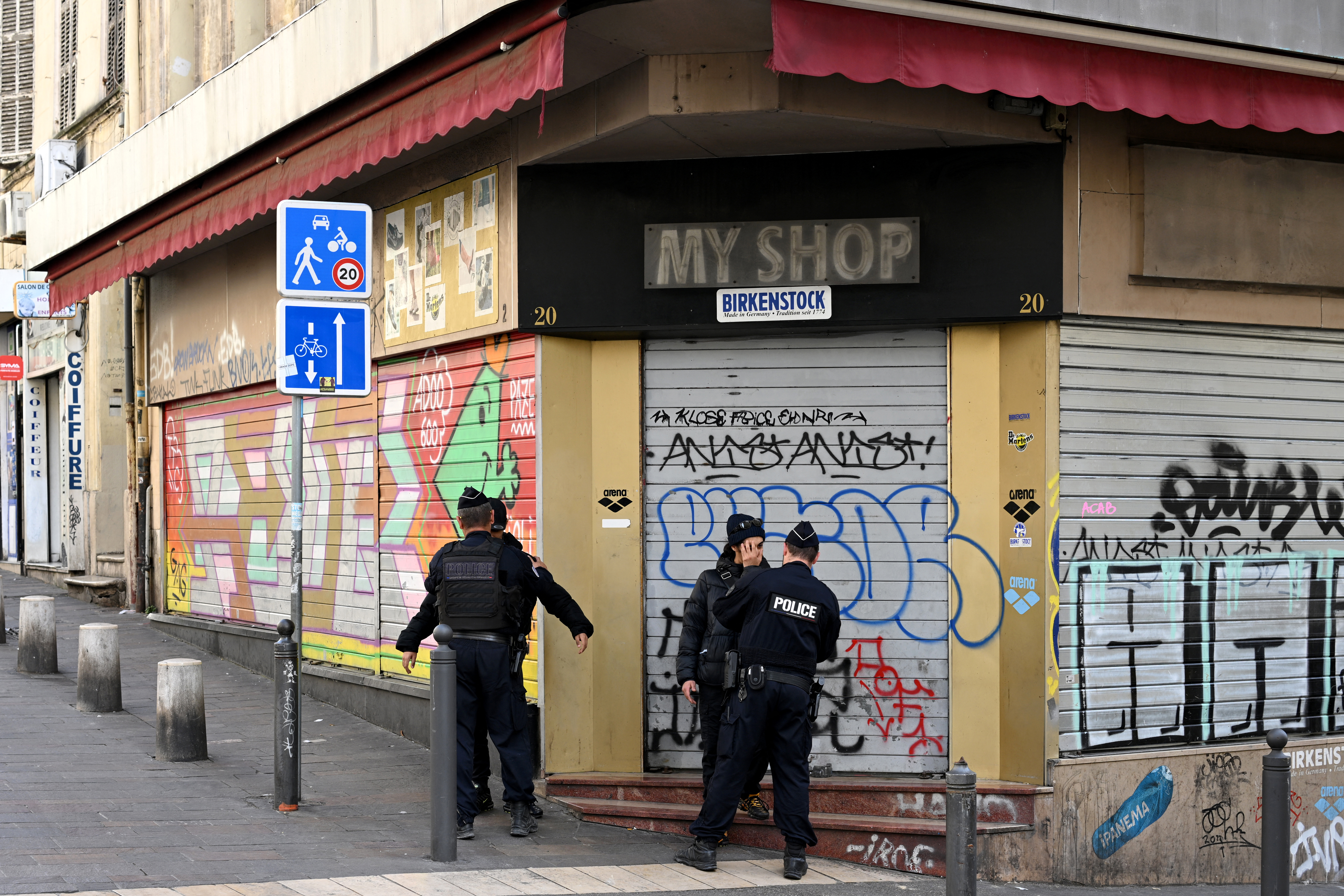 Police officers check young men's identity in downtown Marseille, southern France, on March 21, 2024, two days after the visit of the French president focused on security and drug trafficking. Emmanuel Macron launched on March 19, 2024 a major operation against drug trafficking in Marseille and other French cities, saying that gangland battles that last year left dozens dead had made life a misery for residents. (Photo by Nicolas TUCAT / AFP)