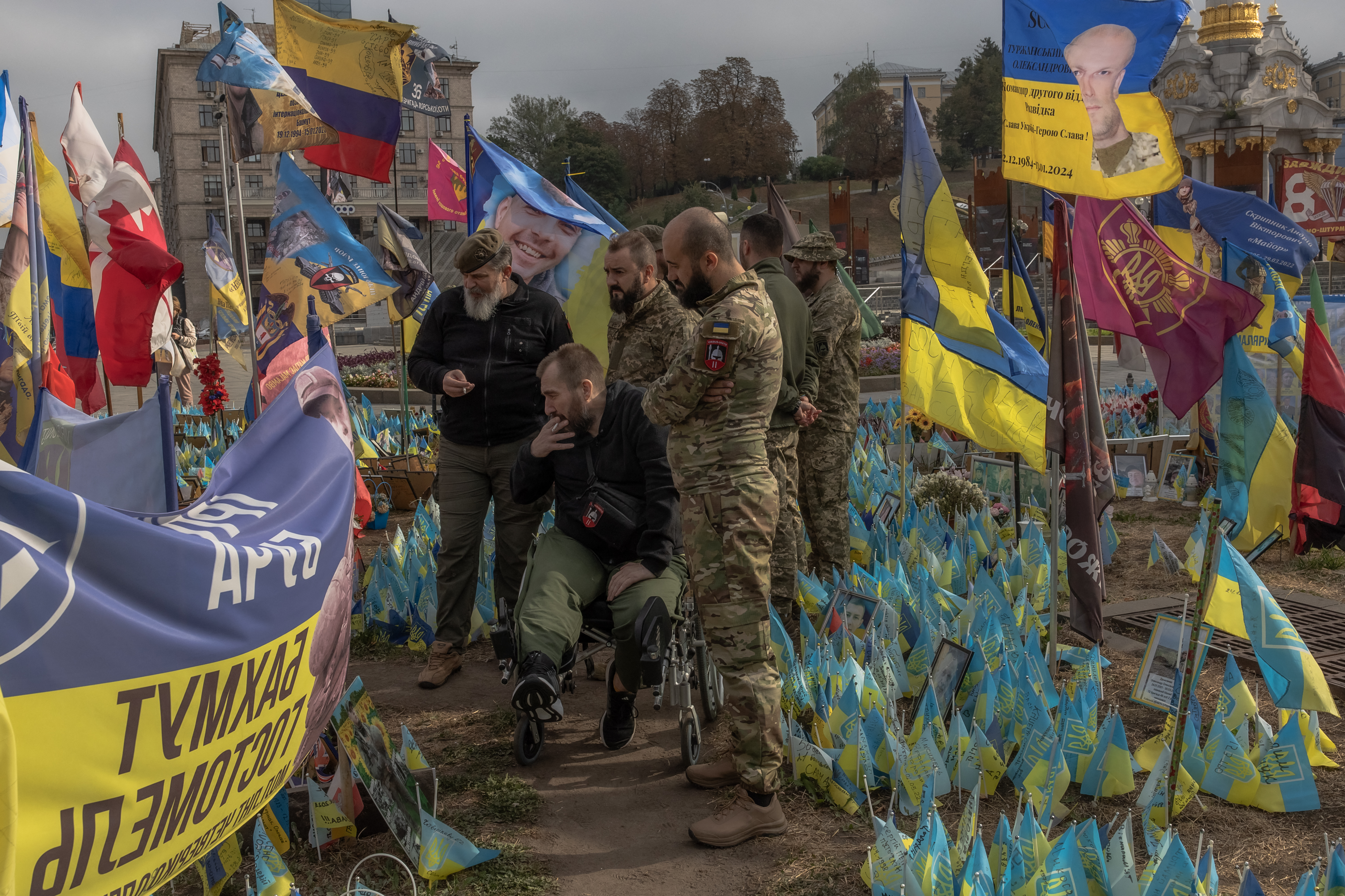 Members of the Armed Forces of Ukraine visit the makeshift memorial commemorating Ukrainian and foreign fighters on "Defenders Day", at the Independence Square in Kyiv, on October 1, 2024.