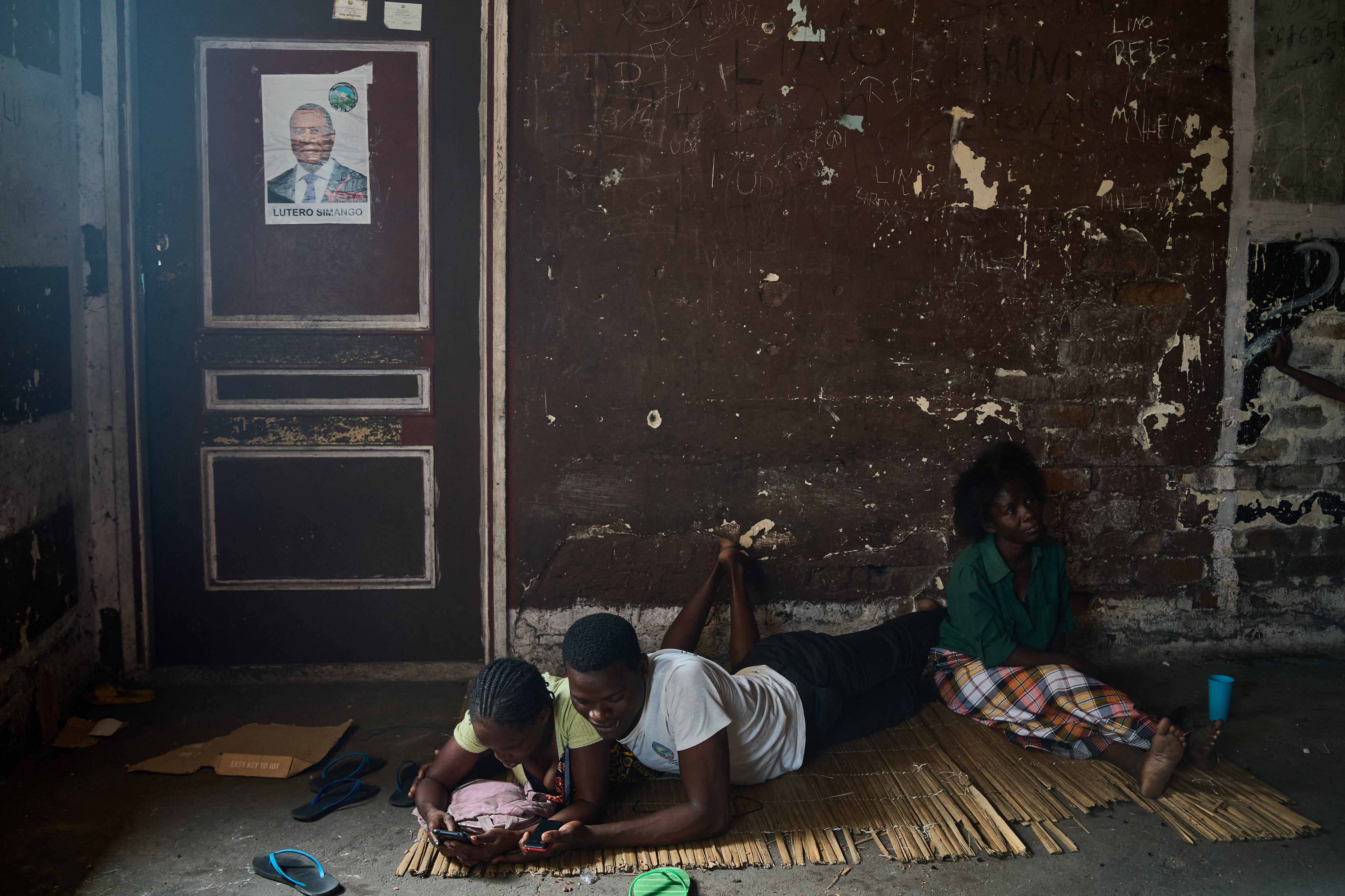 Elaria Ribeiro Punte (R), with her son and his wife, sit in the passage outside their room at the Grande Hotel in Beira on October 12