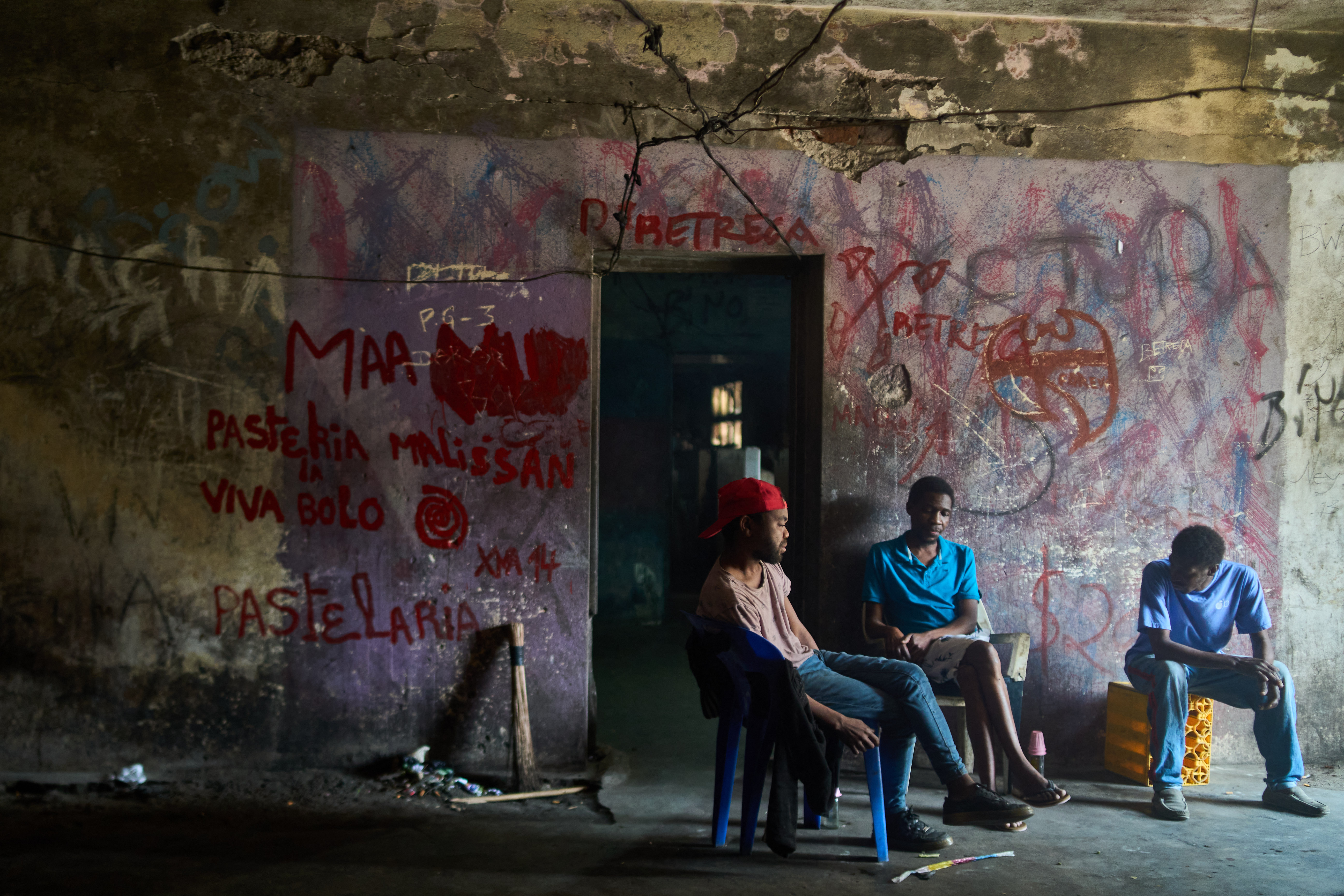 Men sit beside a doorway the Grande Hotel in Beira on October 12