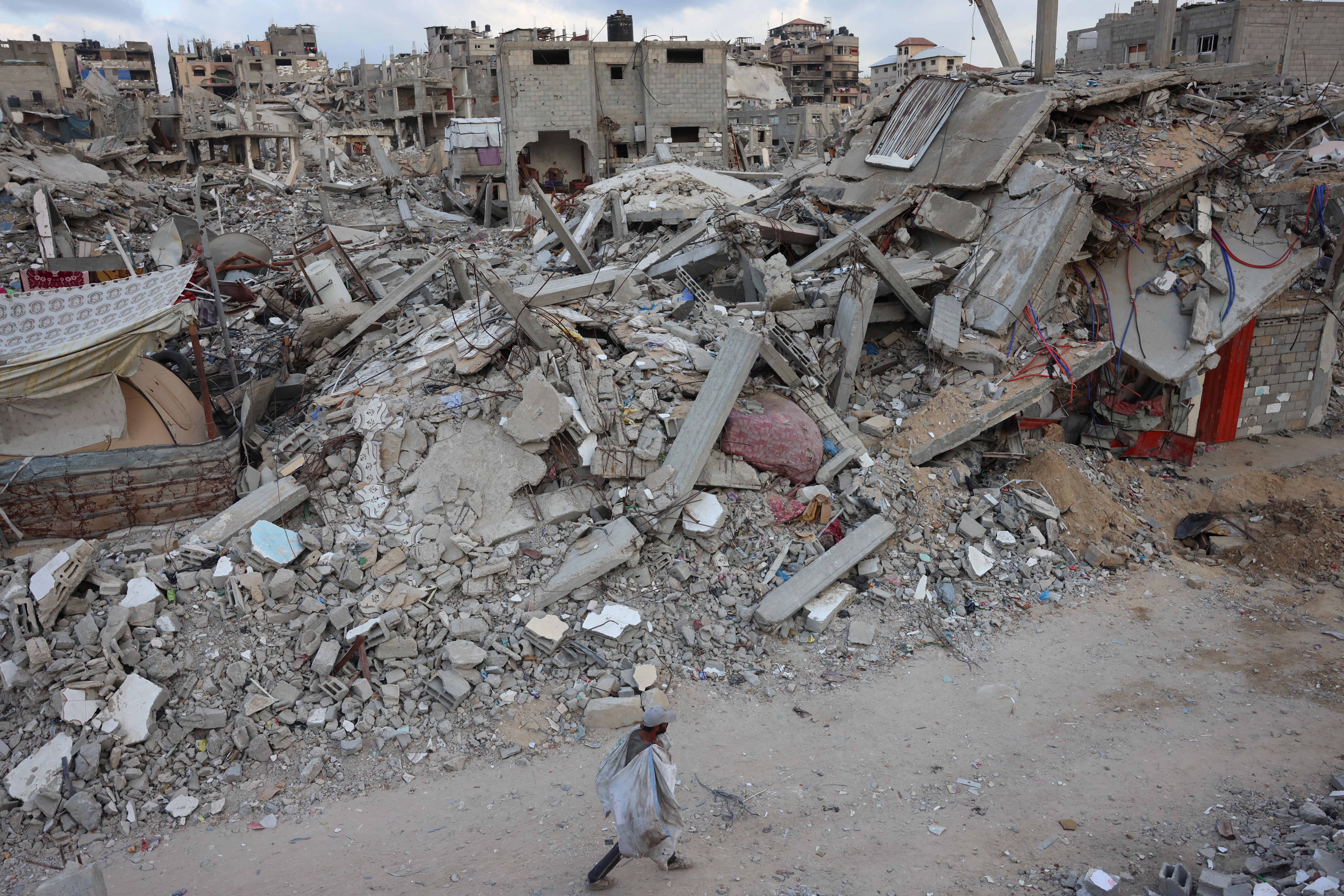 A man walks past destroyed buildings in Khan Yunis in the southern Gaza Strip on October 17, 2024