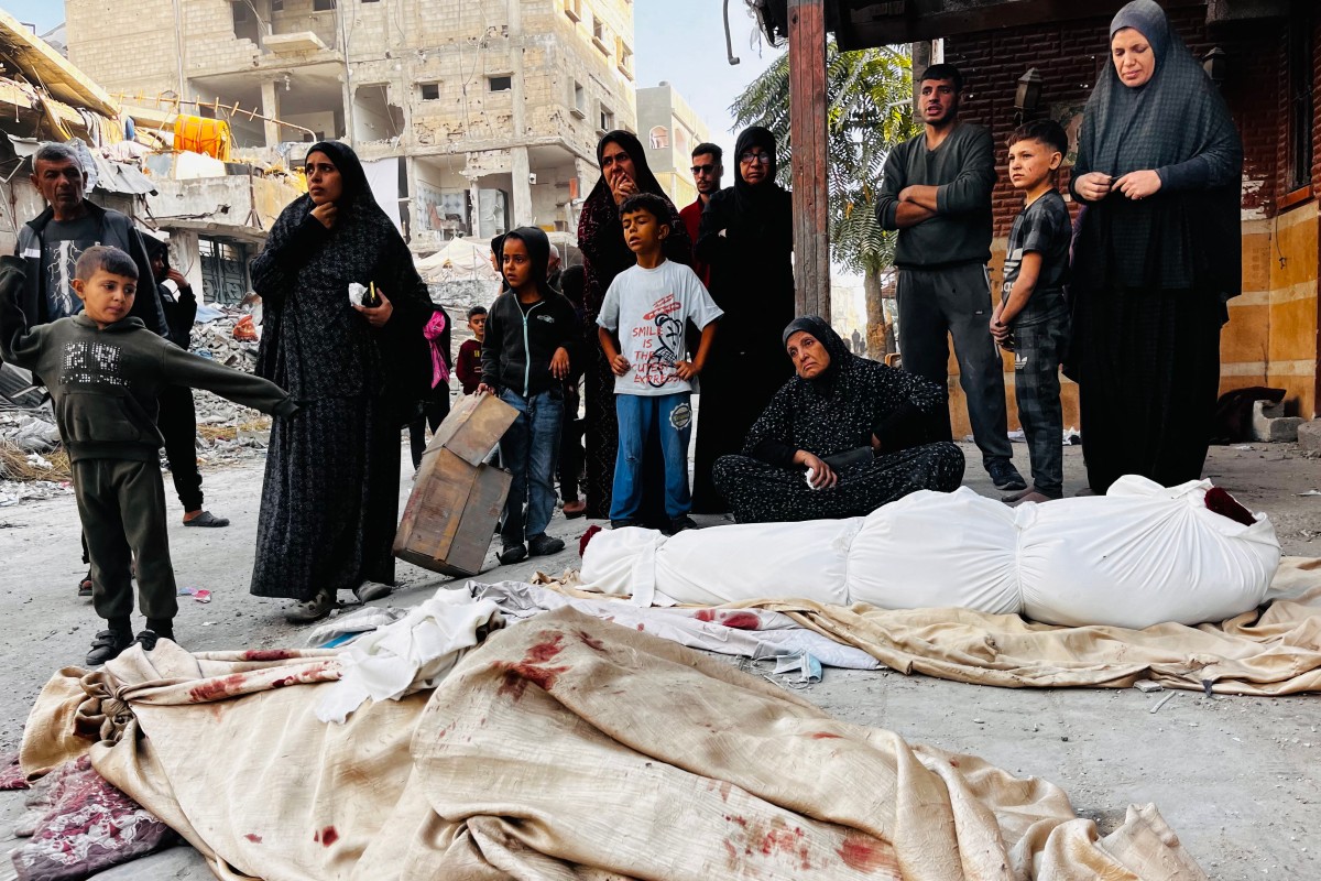 Palestinians mourn over the bodies of relatives after an Israeli strike