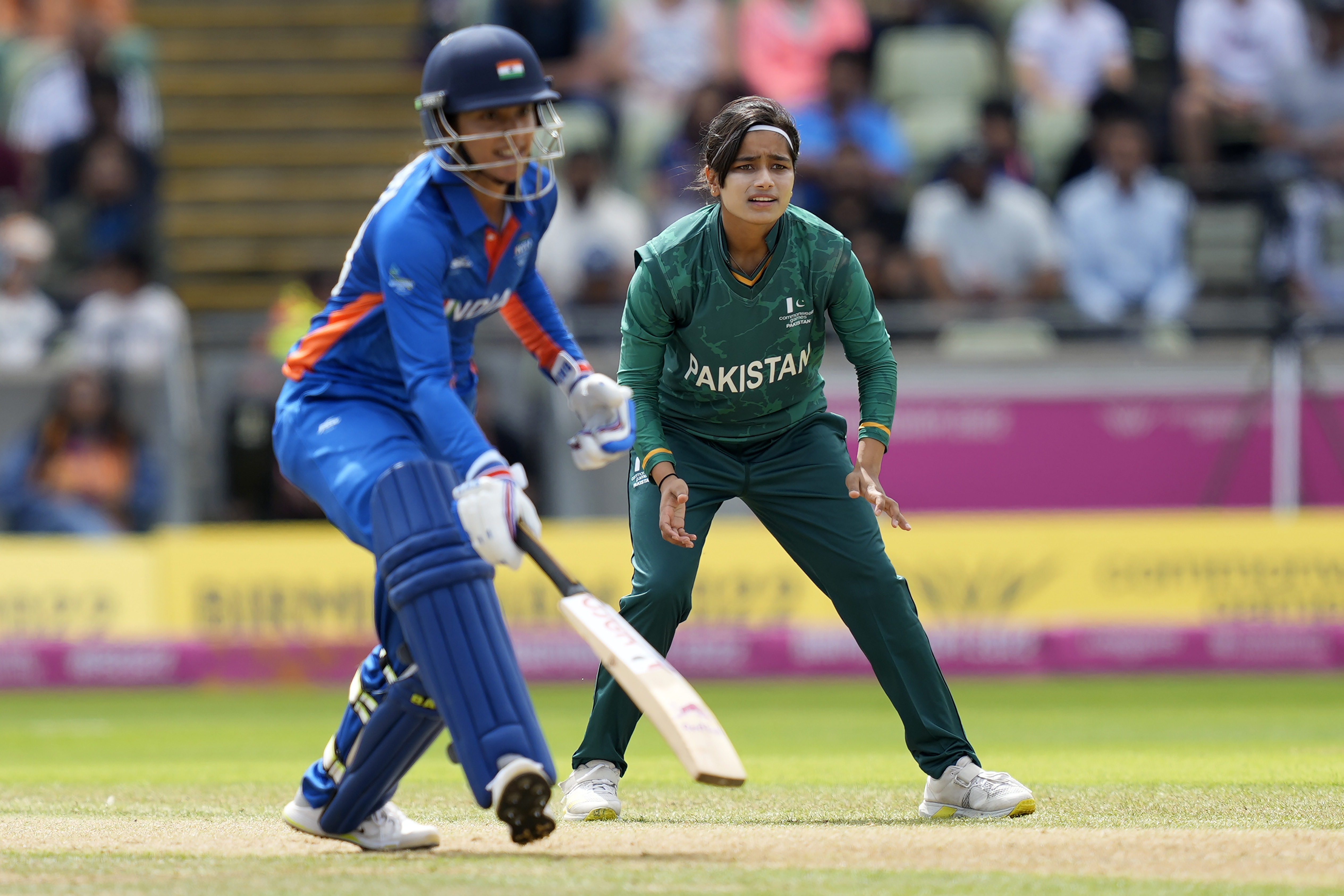 Pakistan's bowler Fatima Sana, right, reacts as India's Smriti Mandhana, left, runs between the wickets to score during the women's cricket T20 preliminary round match between India and Pakistan at the Commonwealth Games in Birmingham, England, Sunday, July 31, 2022. (AP Photo/Aijaz Rahi)