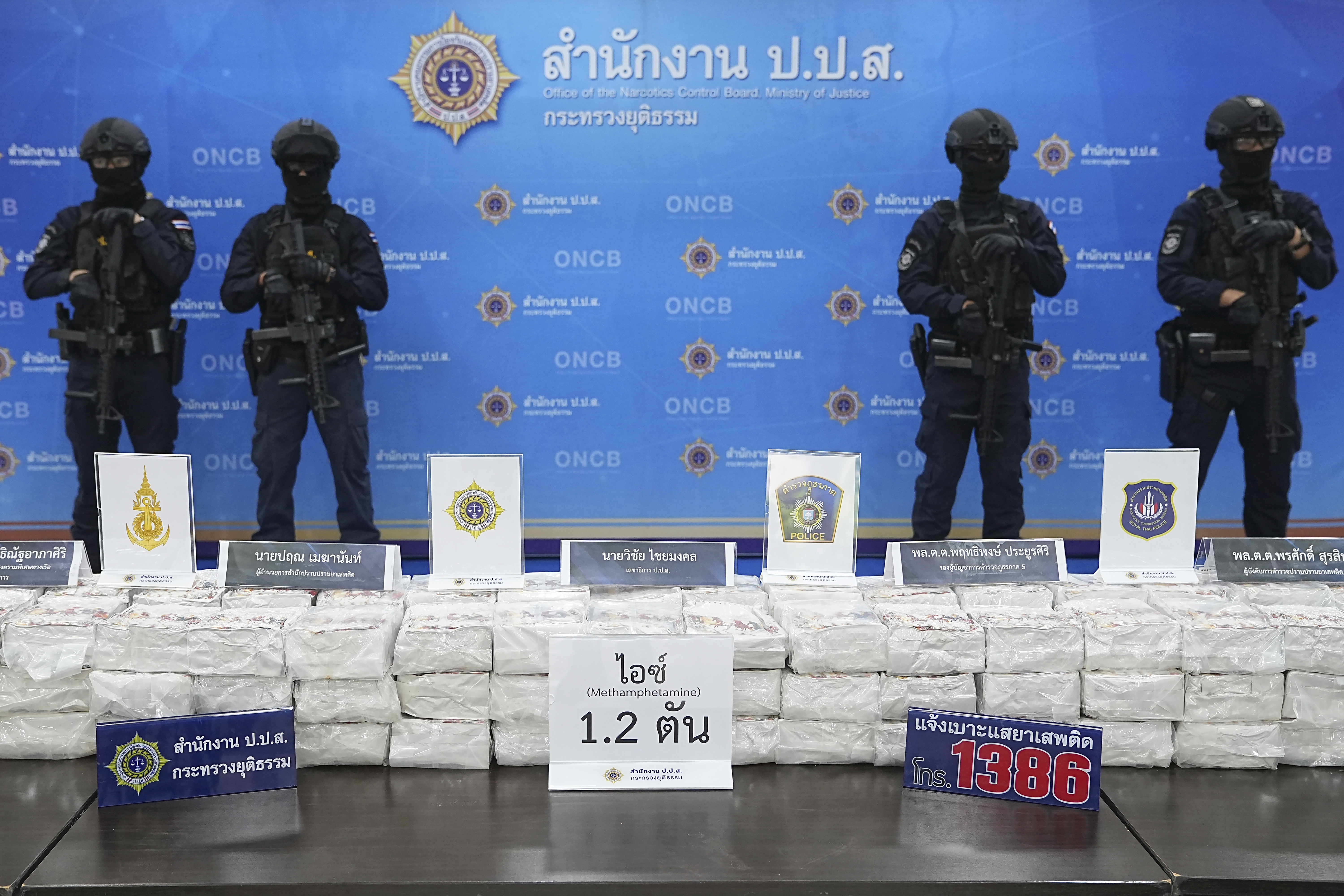 A haul of methamphetamine that was destined for Australia. Four armed and masked police officers are standing behind the haul