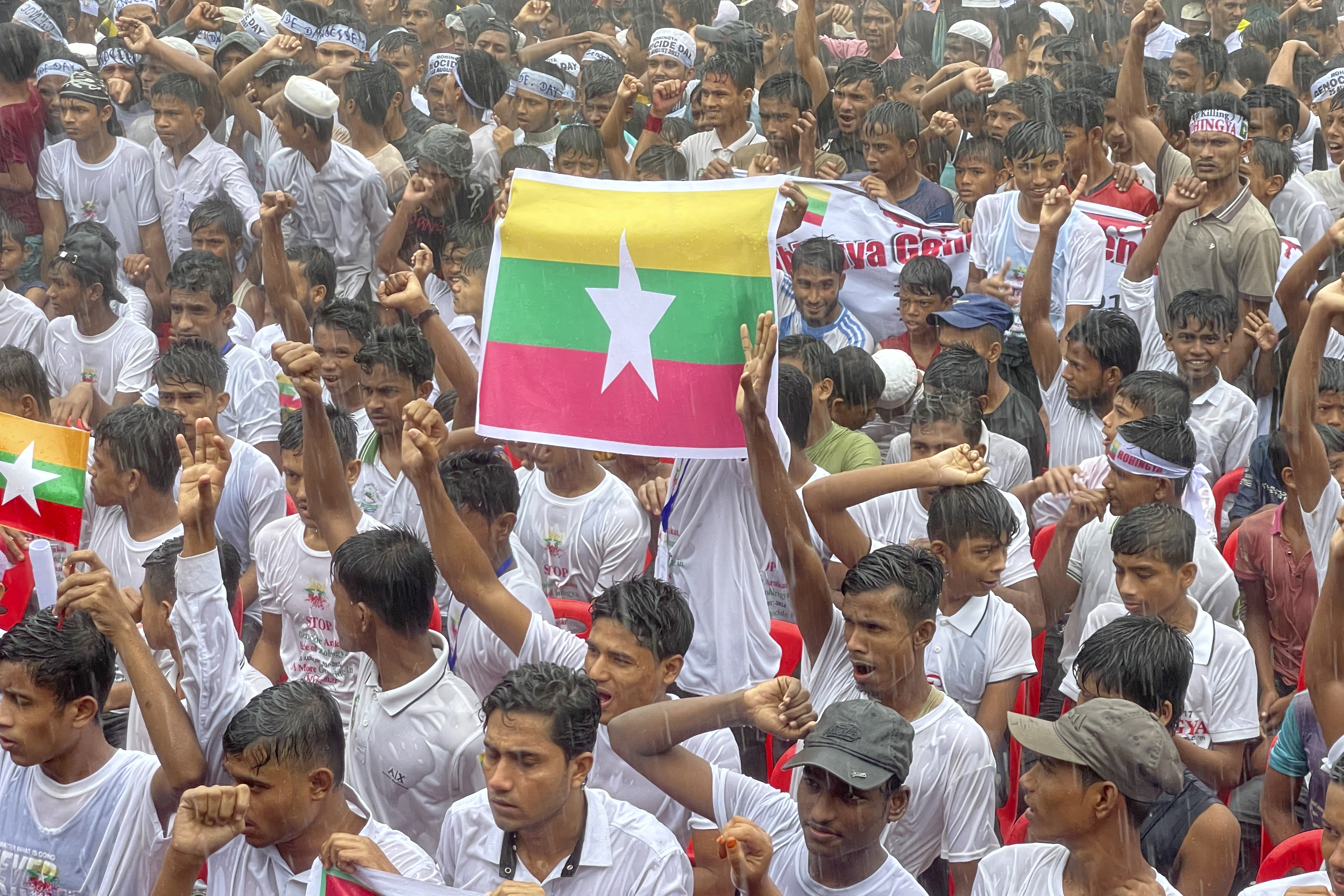 Rohingya refugees in Bangladesh holding a protest. One person is holding up a Myanmar flag.