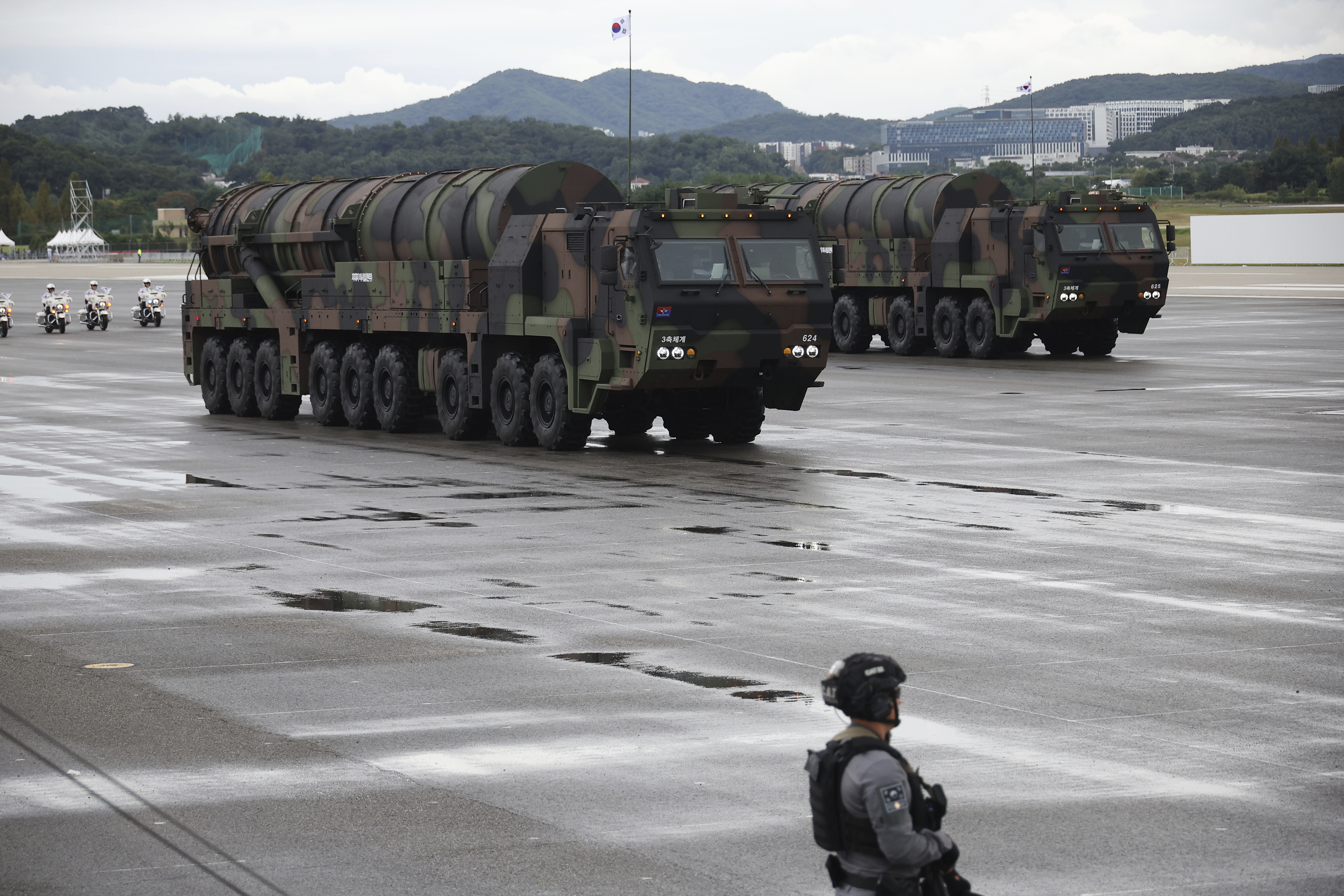 The Hyunmoo-5 on a transporter vehicle. A soldier is standing nearby.