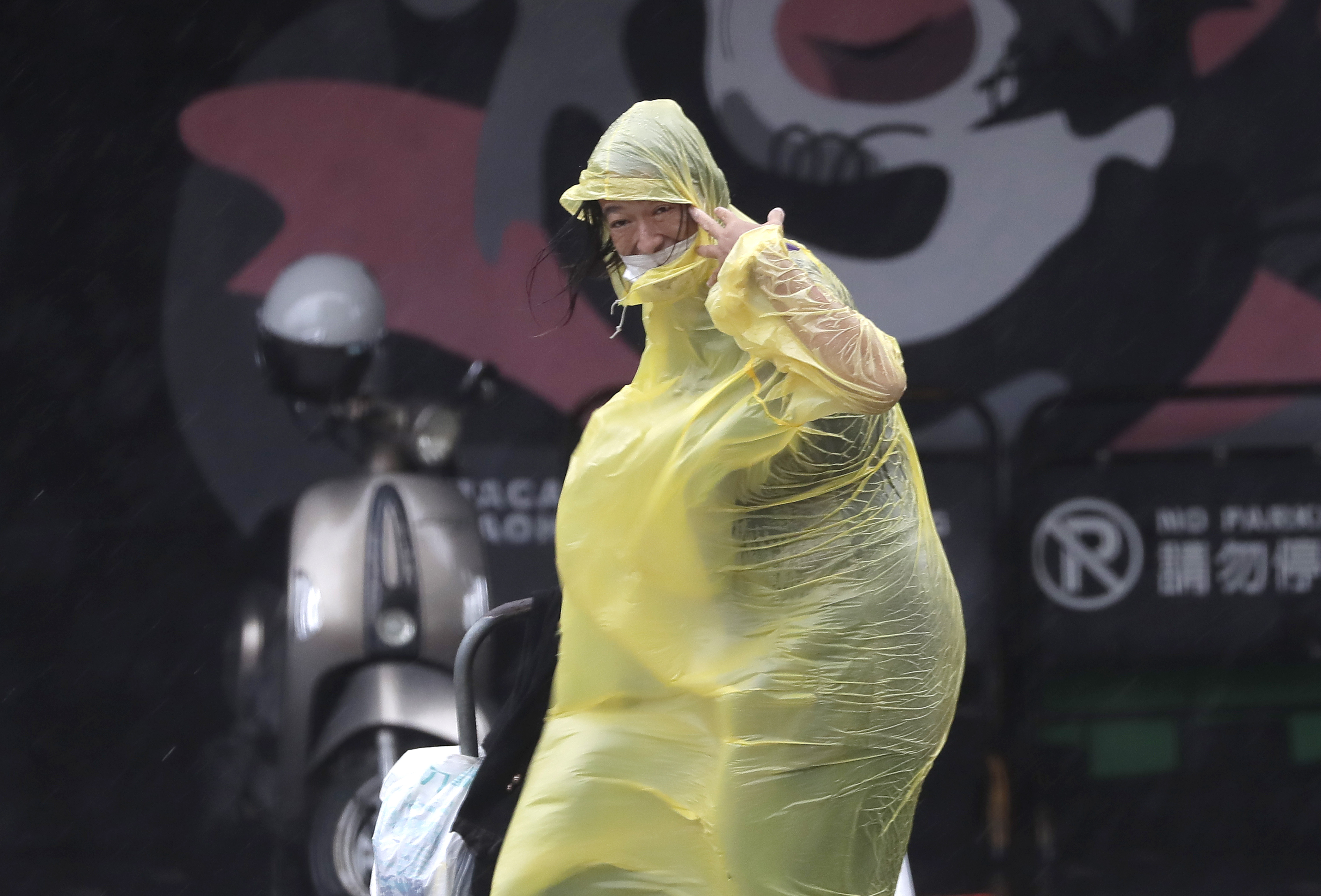 A woman struggles with winds generated by Typhoon Krathon in Kaohsiung, Southern Taiwan, Wednesday, Oct. 2