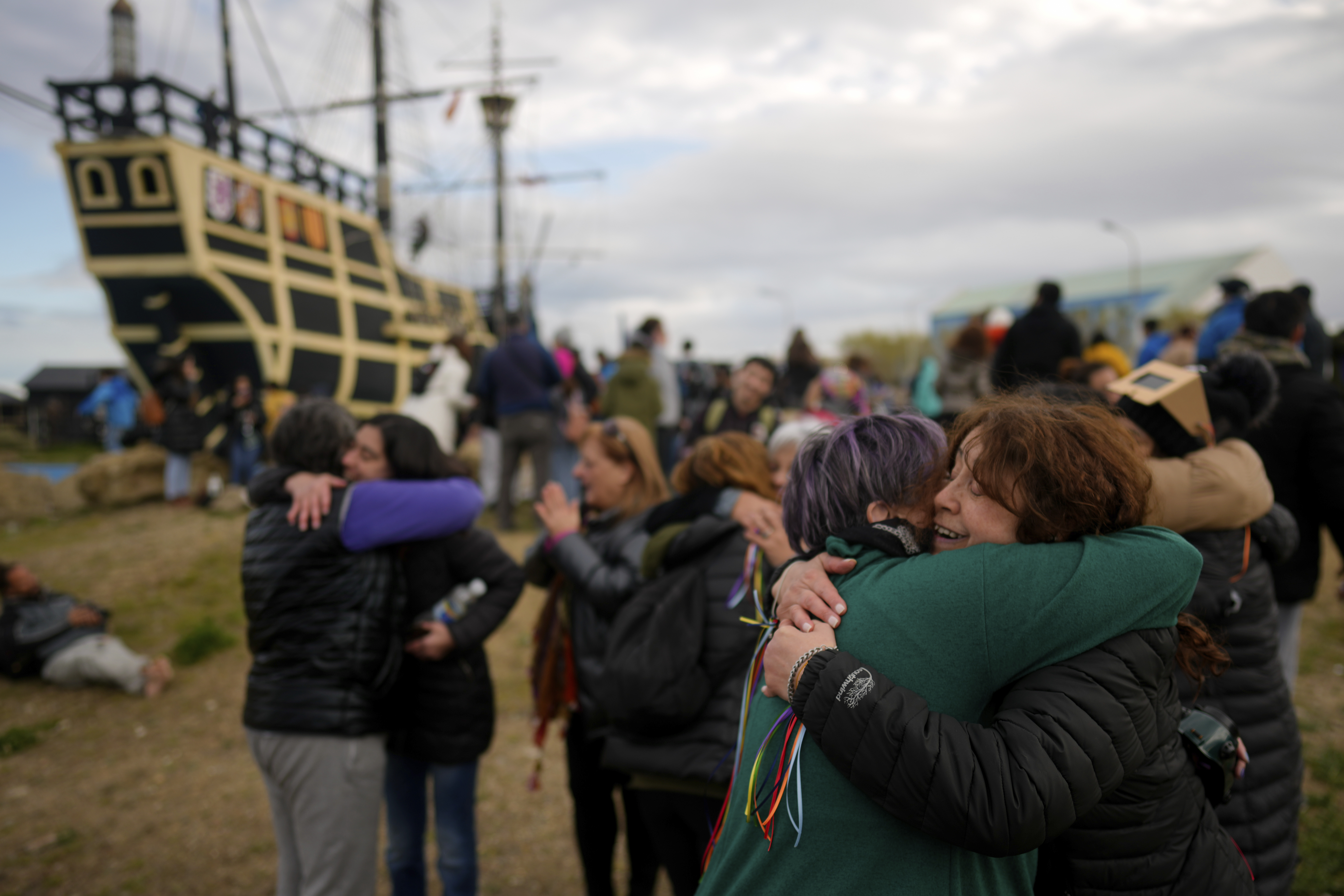 An antique wooden boat and a crowd watching the solar eclipse