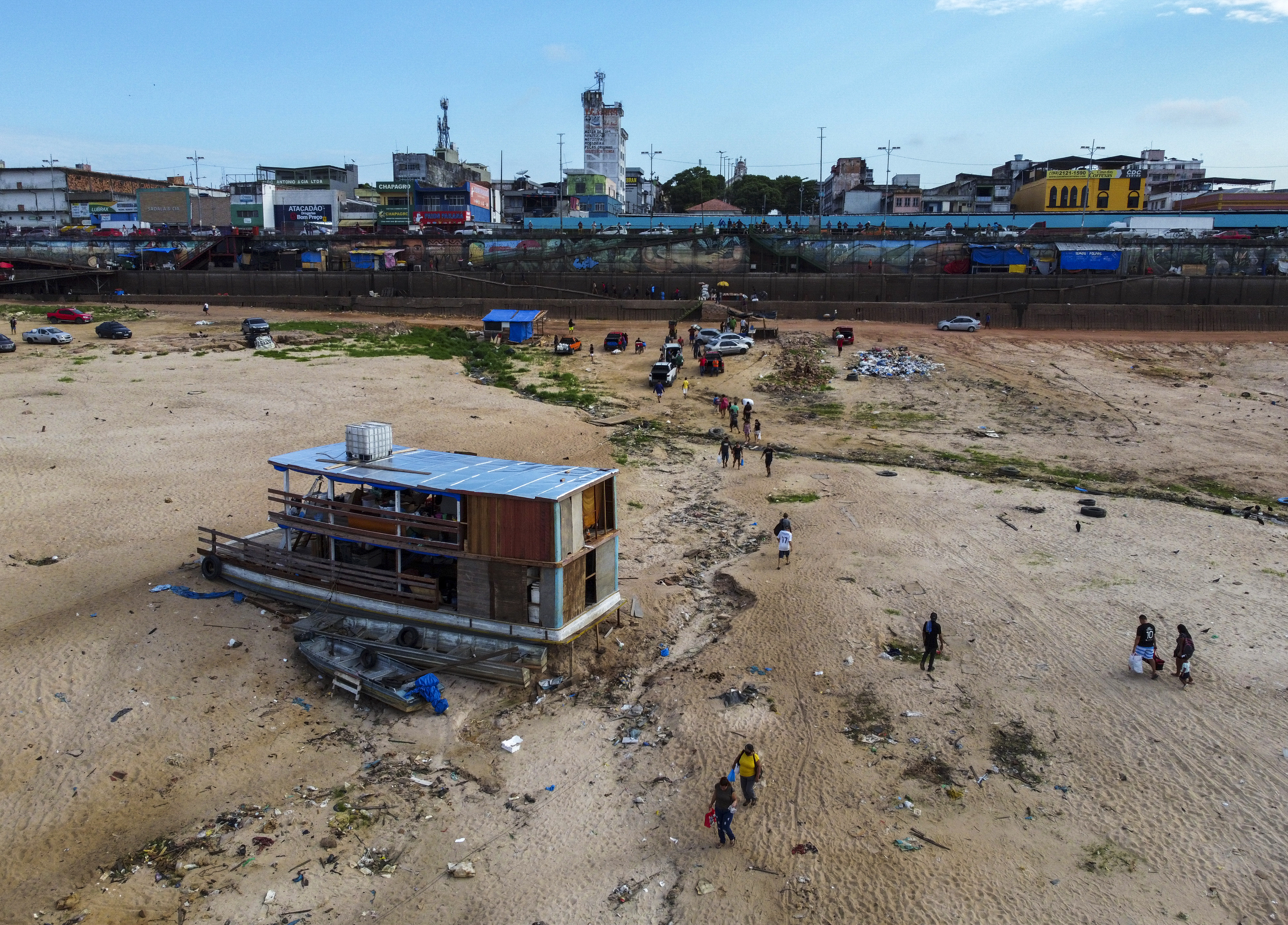 A boat with a blue roof sits on a dry riverbed where the Rio Negro used to flow.