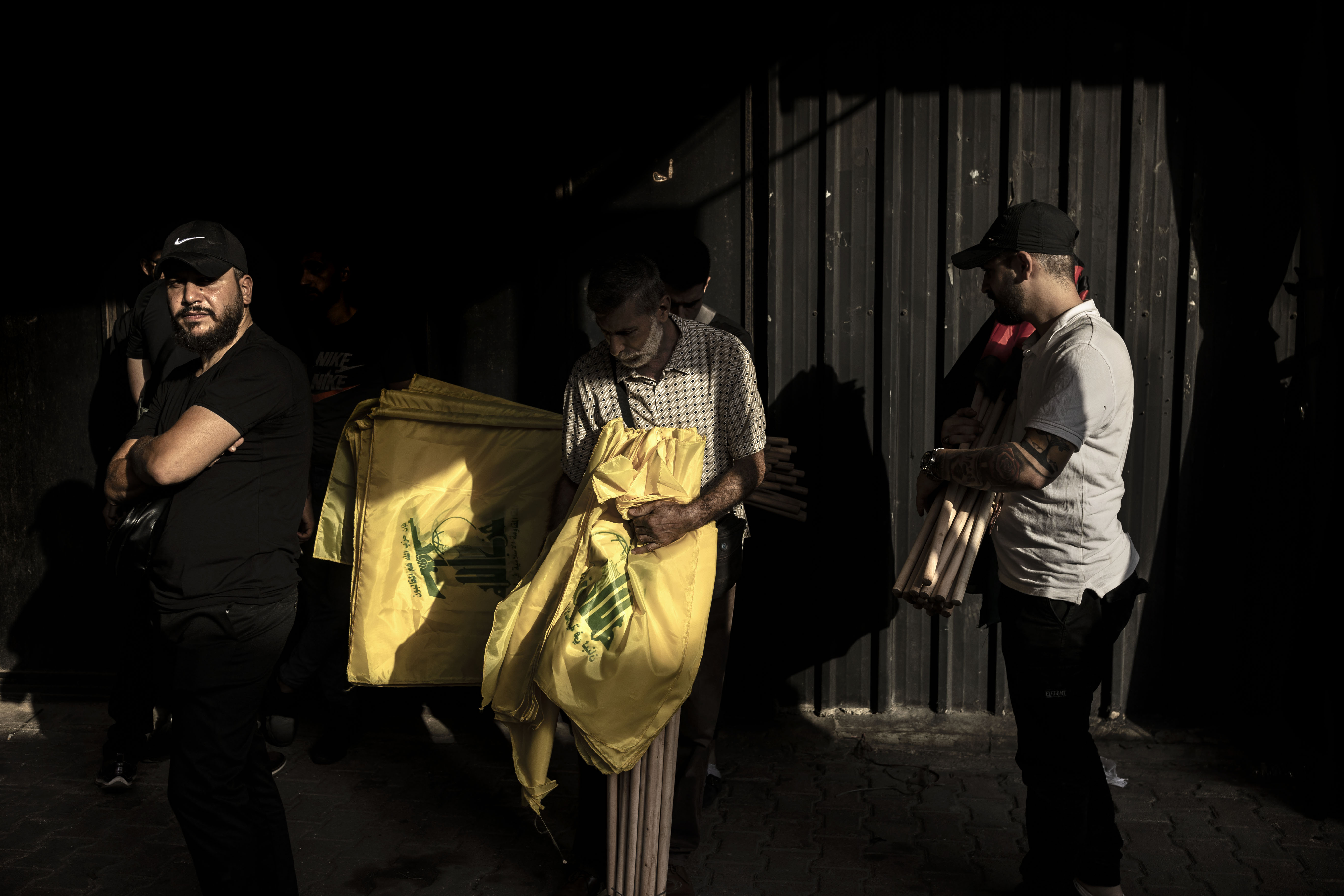 Hezbollah supporters hold flags to distribute among the attendants moments before the beginning of the funeral of a Hezbollah militant killed by IDF while clashing yesterday in southern Lebanon yesterday, through the streets of Dahieh district on October 23, 2023 in Beirut, Lebanon. Lebanese Hezbollah announced the death of ten militants in the past 24 hours, bringing to 25 the number killed in its ranks since the large-scale Hamas attack in Israel on October 7. Accentuating the fear of a general conflagration on the Lebanese-Israeli front. (Photo by Manu Brabo/Getty Images)