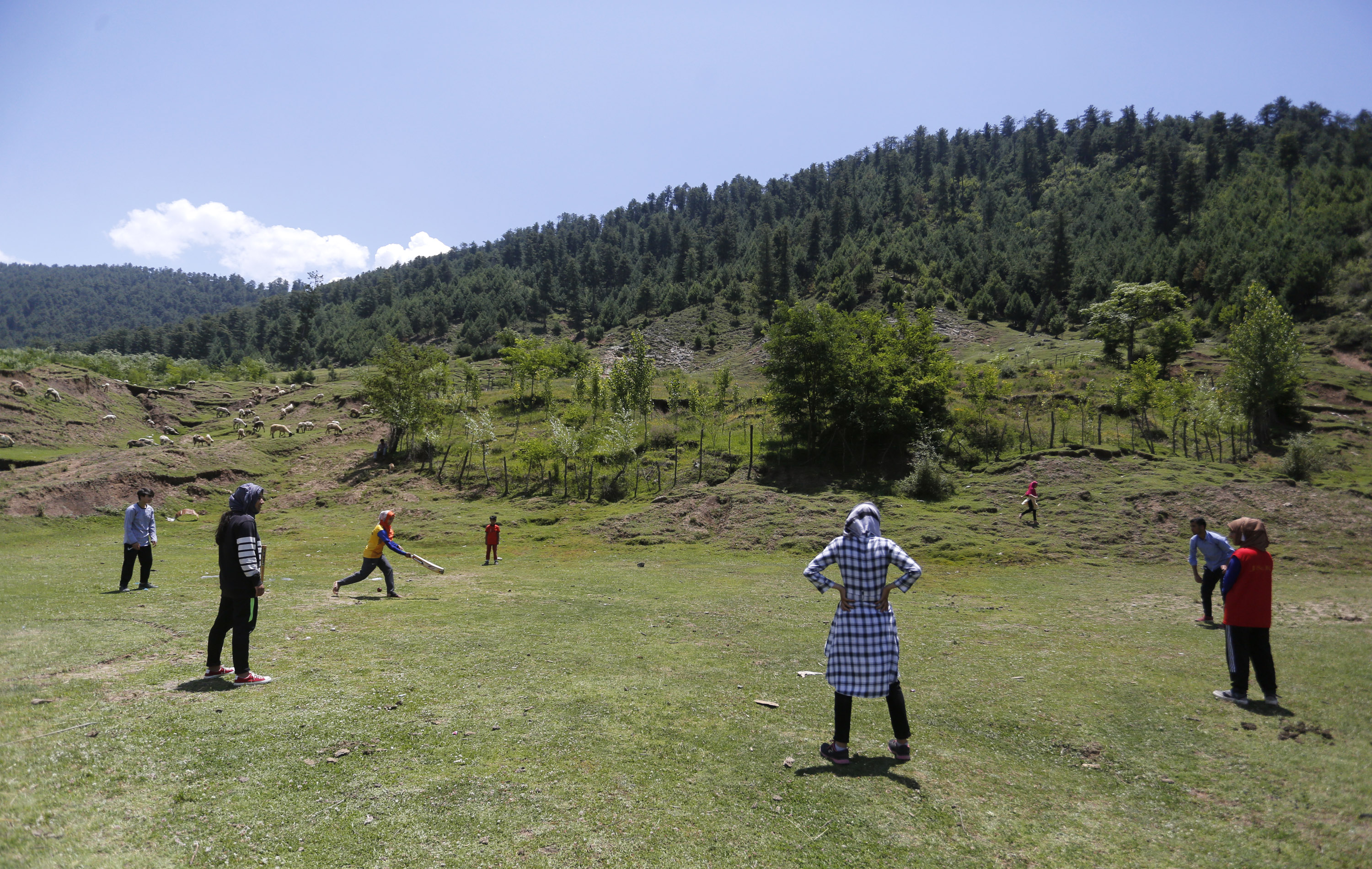 Young boys and girls playing cricket in a scenic village in north Kashmir’s Bandipora district in Indian-administered Kashmir. [Shuaib Bashir/Al Jazeera]