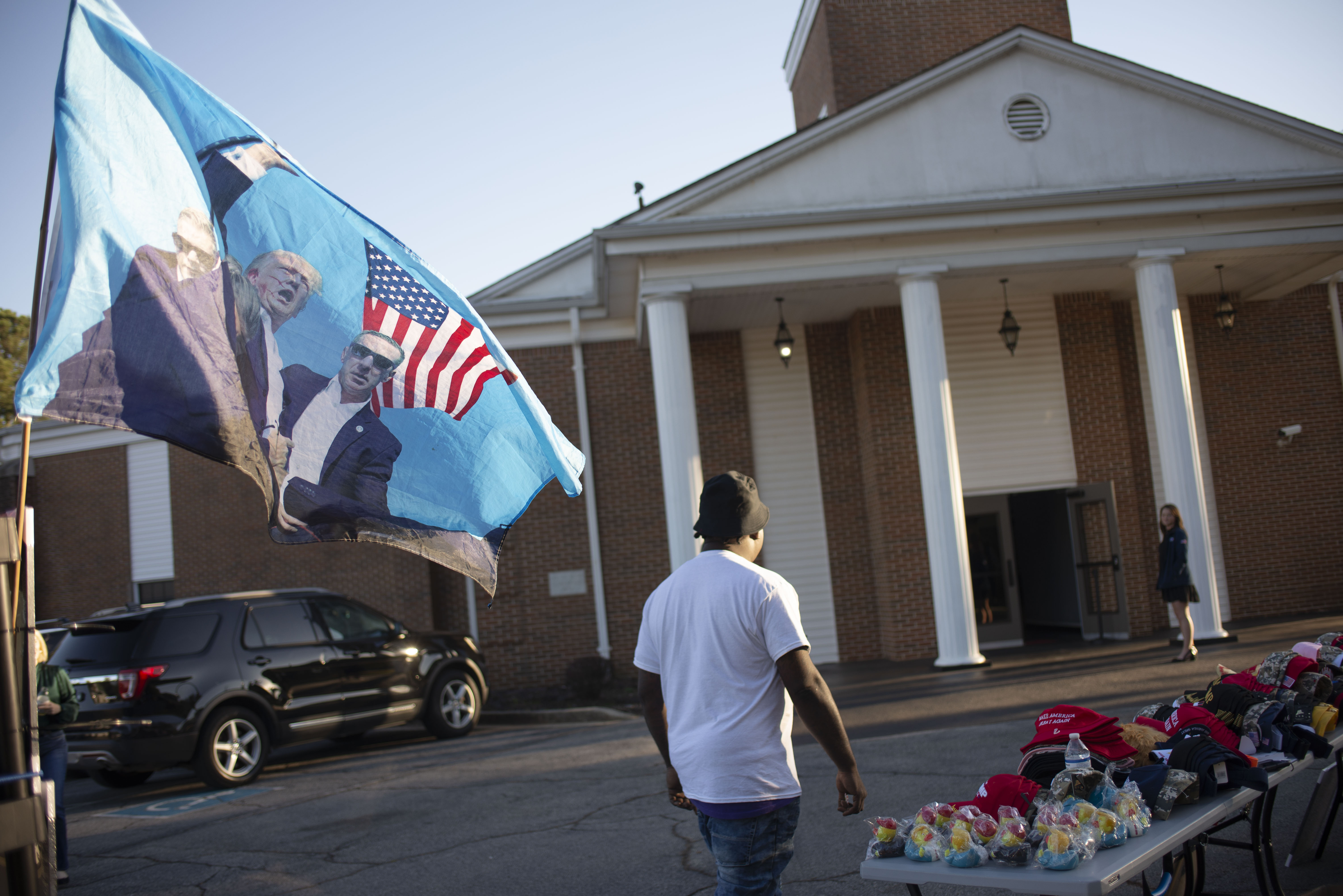A man sells Trump merchandise outside of a 'believers for Trump' event in Austell, Georgia